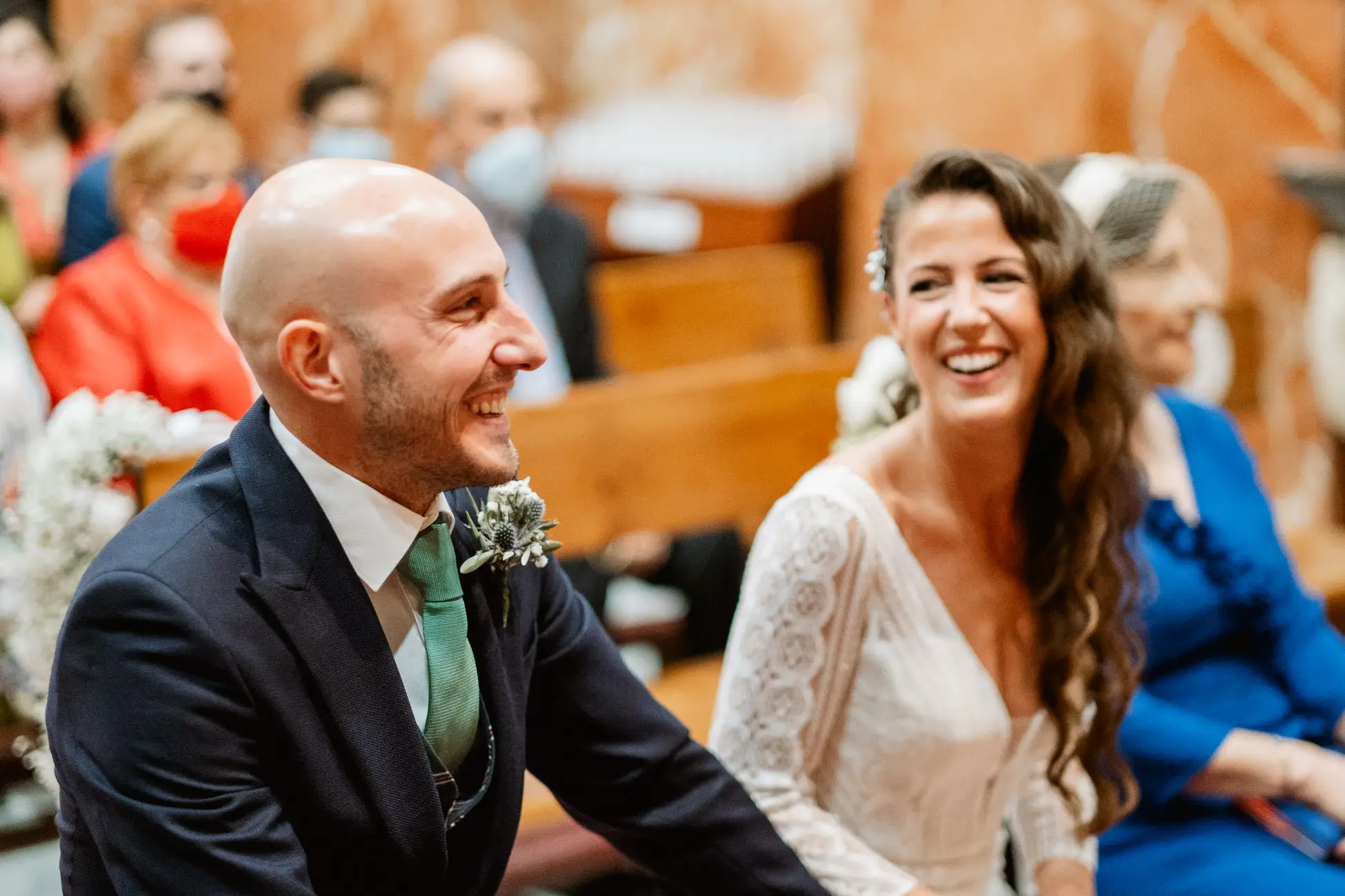Los novios sentados en el altar se miran y sonríen