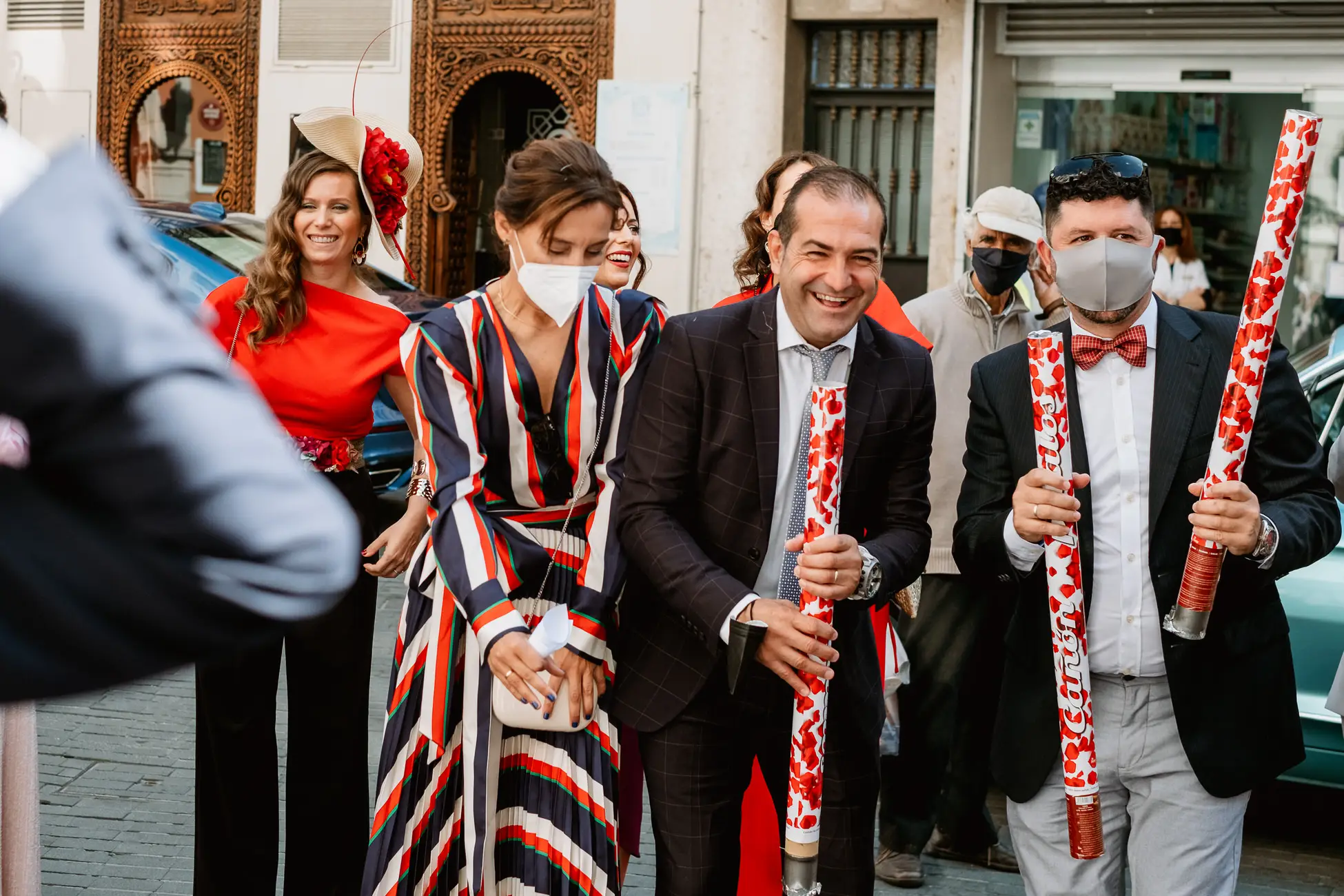Invitados con cañones de confeti esperan a los novios a la salida de la iglesia