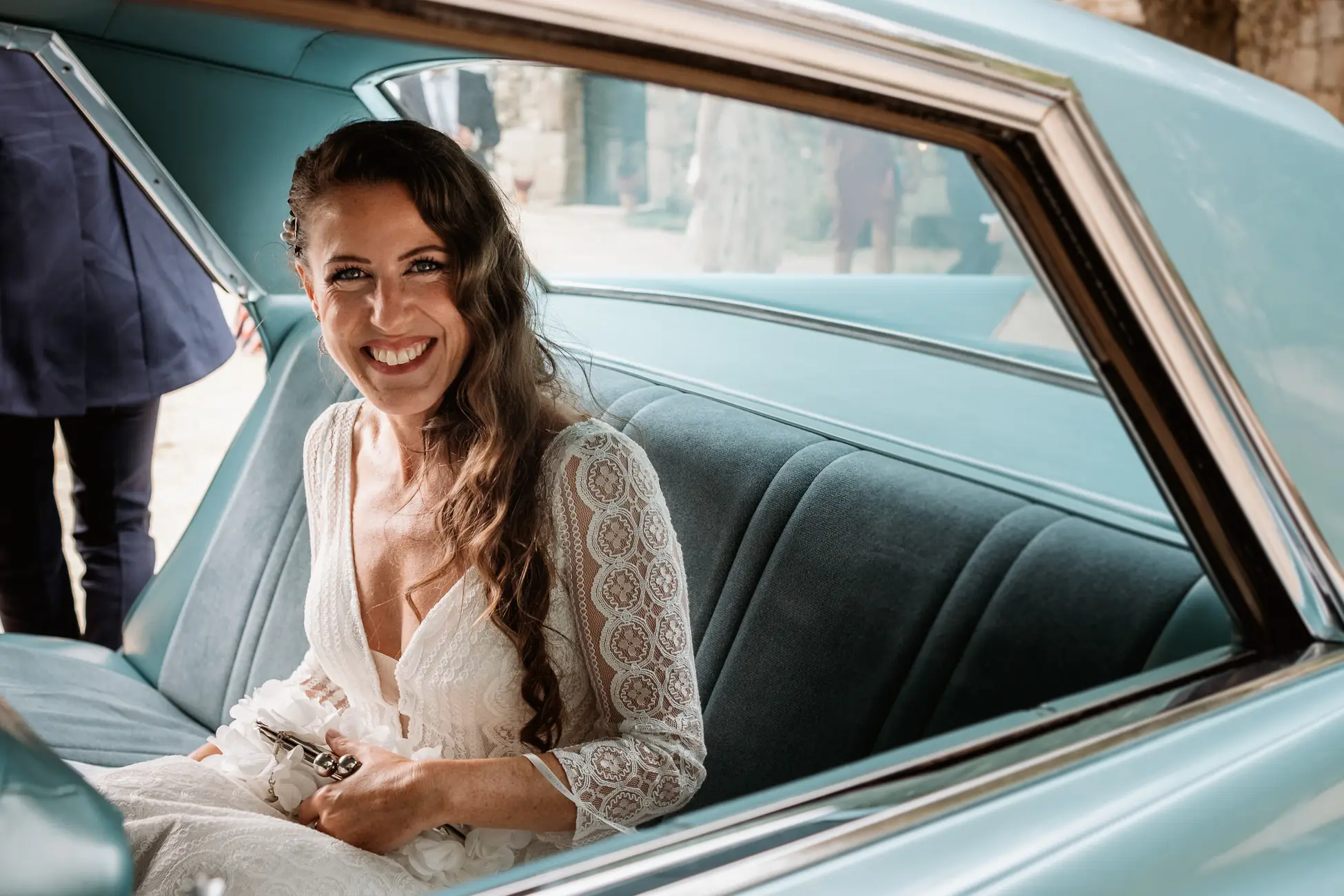 La novia sonríe dentro del coche clásico