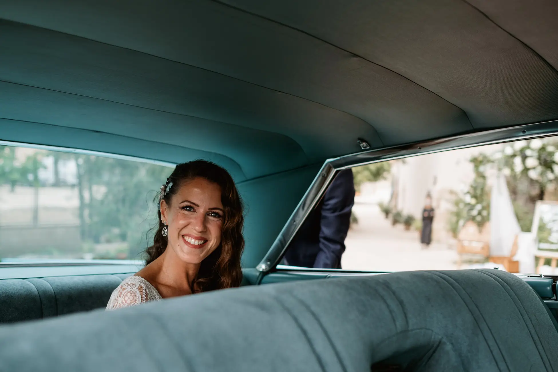 La novia en el asiento trasero del coche clásico