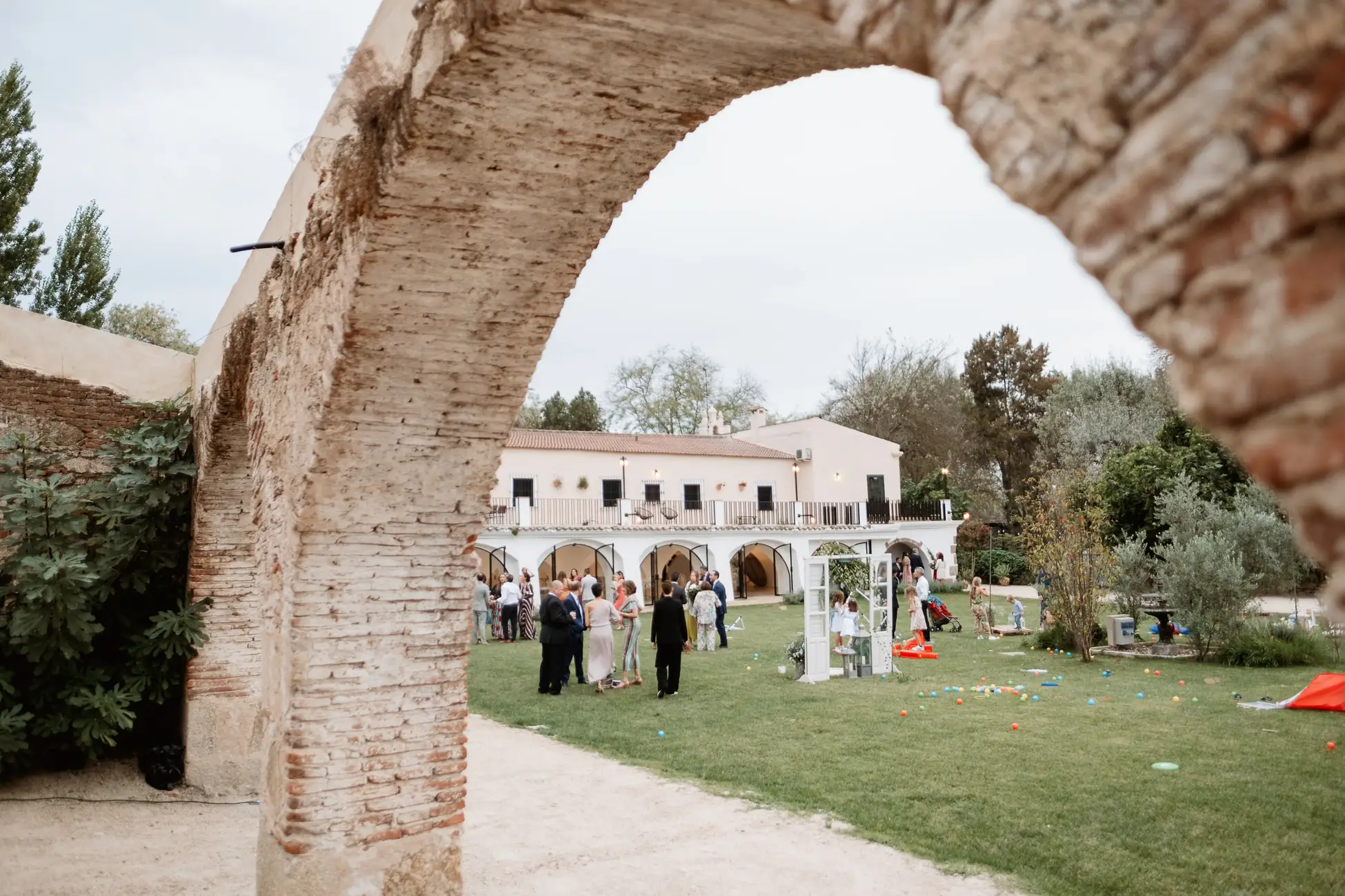Arco de piedra del antiguo lavadero con el jardín al fondo