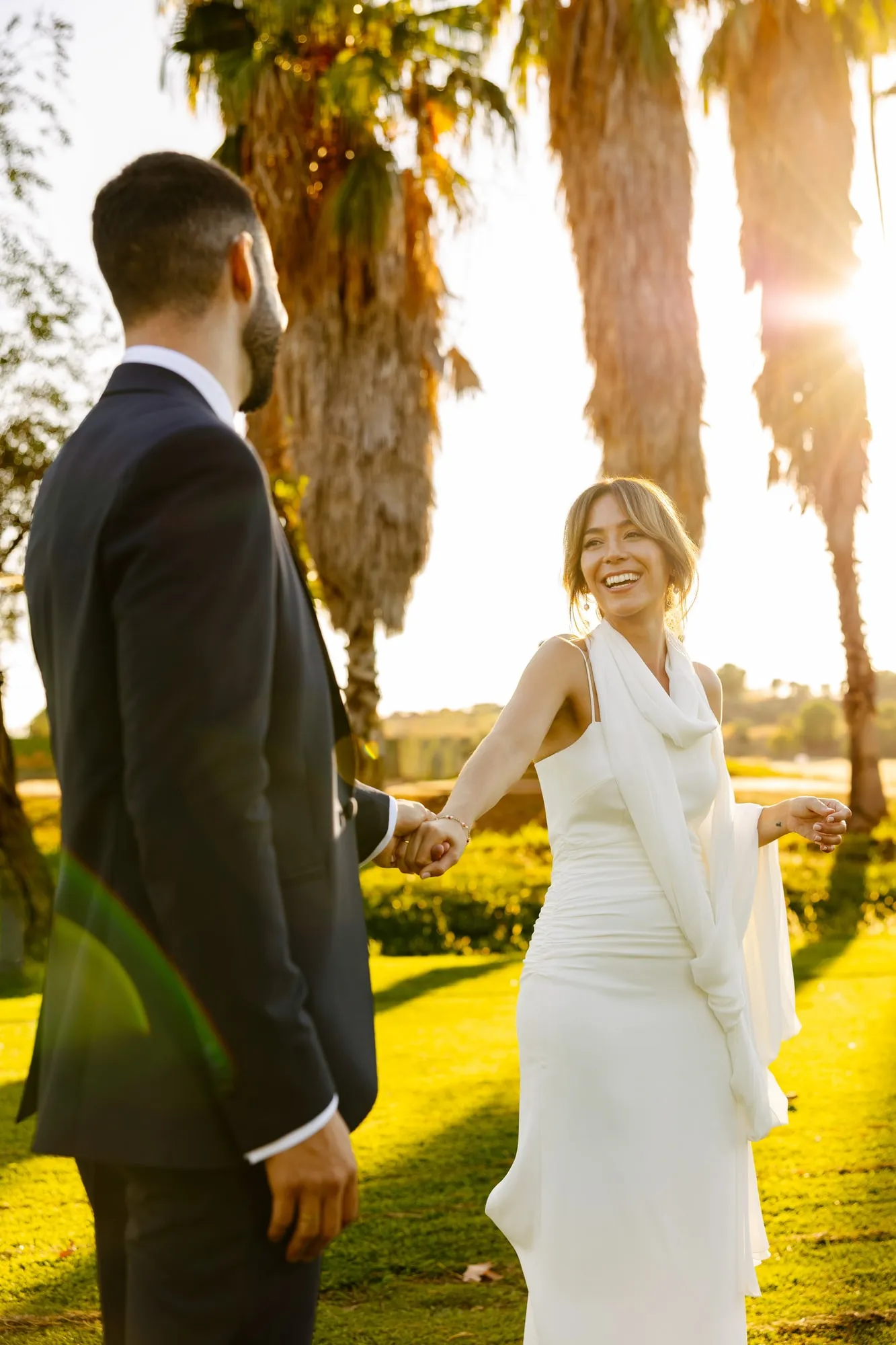 Los novios se cogen de la mano al atardecer entre las palmeras del Golf Guadiana (Badajoz)
