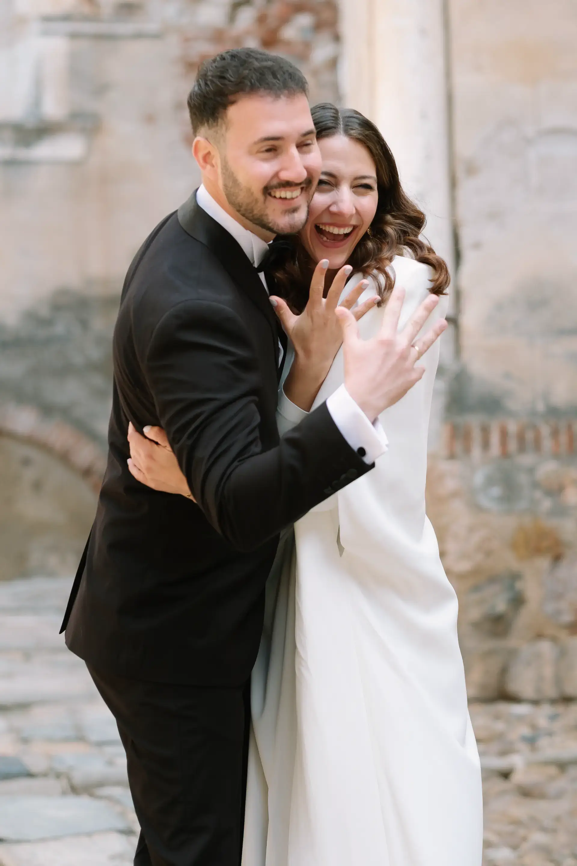 Ana y Jorge ríen abrazados junto a la muralla, en Badajoz