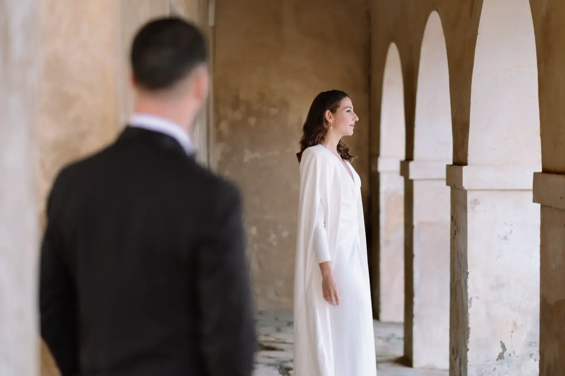 Ana mira a Jorge bajo unos arcos de piedra, en Badajoz