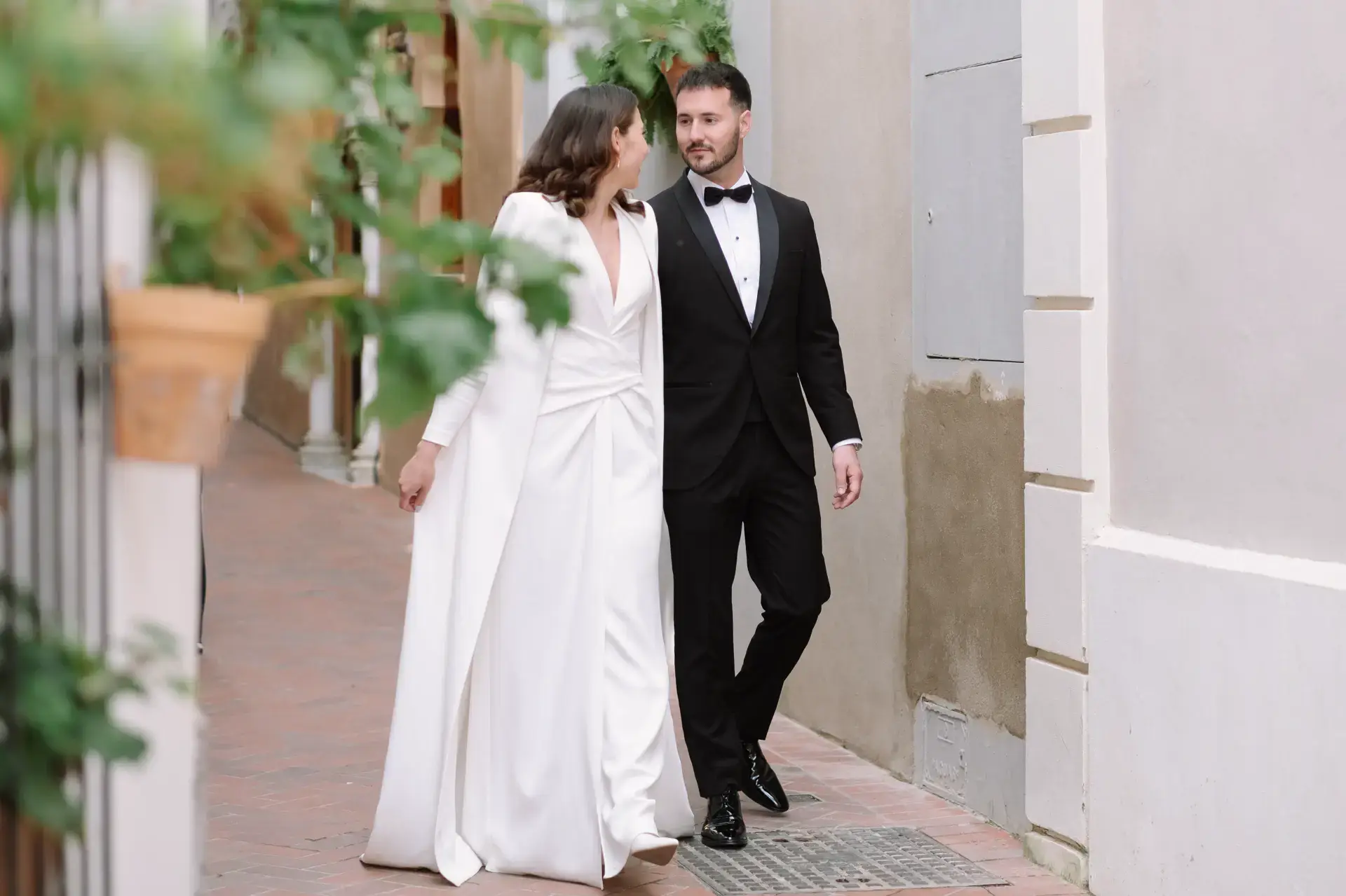 Ana y Jorge caminan por una calle blanca con macetas, en Badajoz