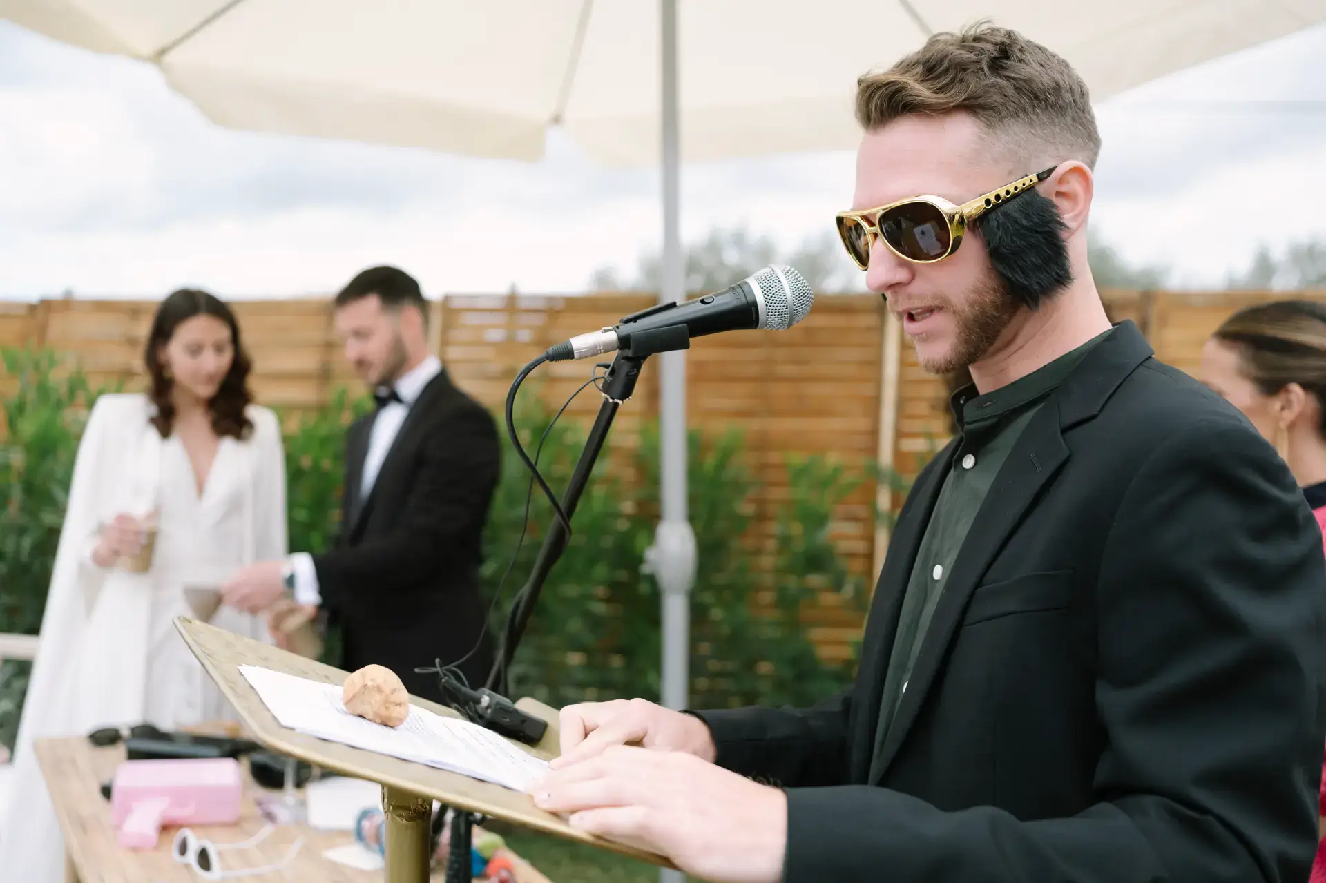 Un amigo con gafas de sol lee un texto con micrófono, en Badajoz