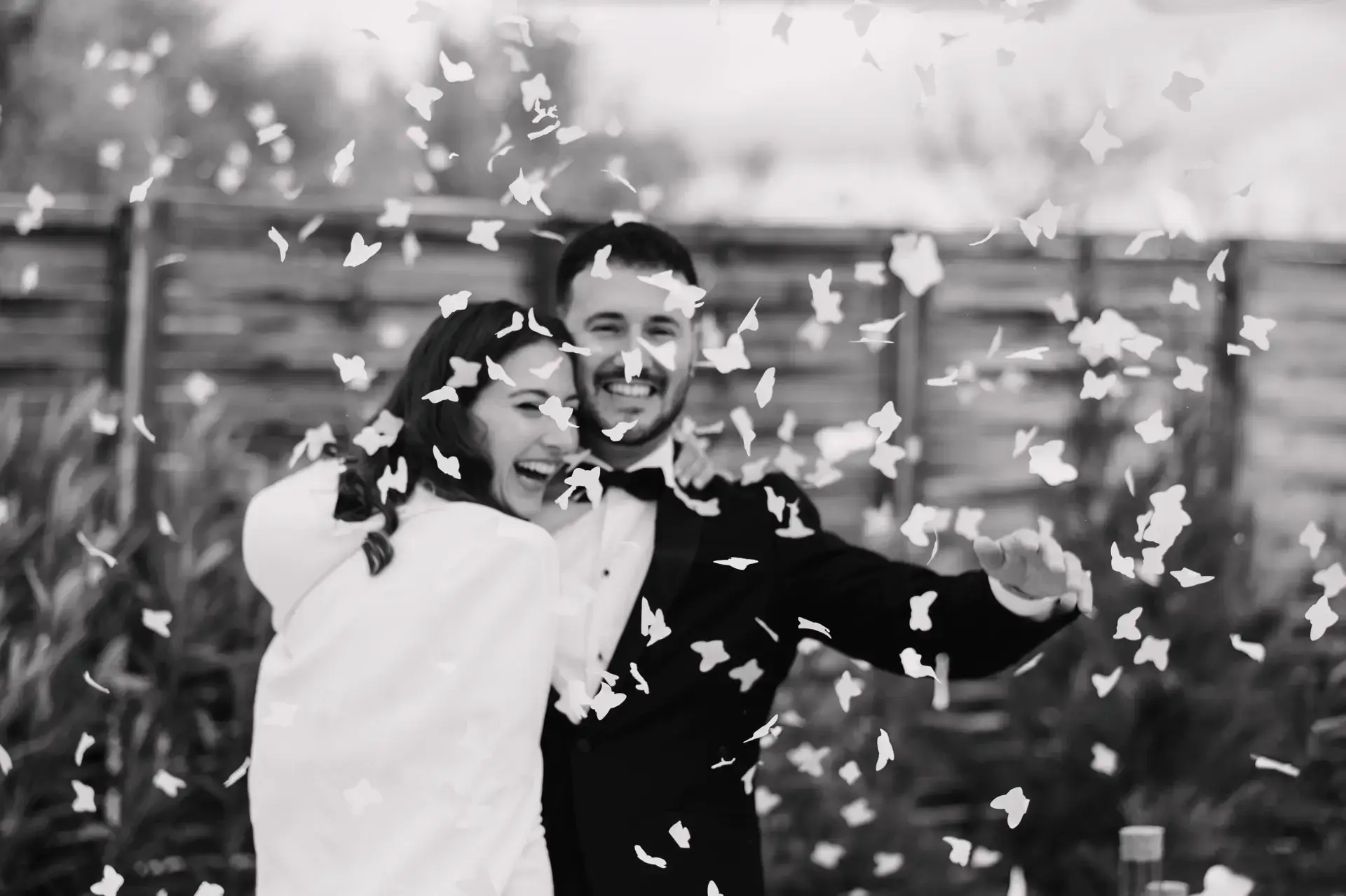 Ana y Jorge abrazados bajo una lluvia de confeti, en blanco y negro, en Badajoz