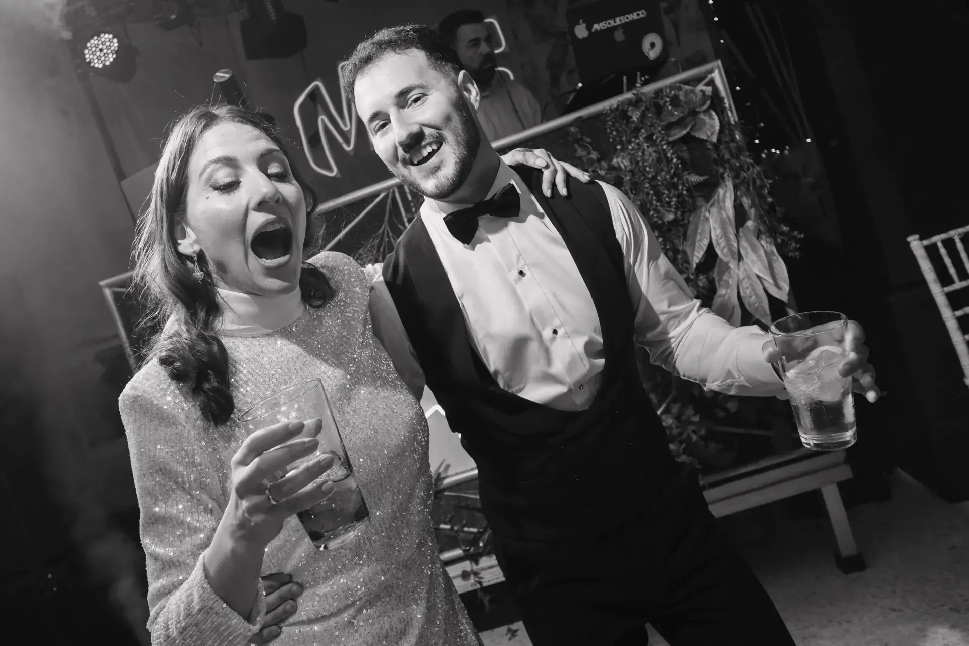 Ana y Jorge cantan con una copa en la mano, en blanco y negro, en Badajoz
