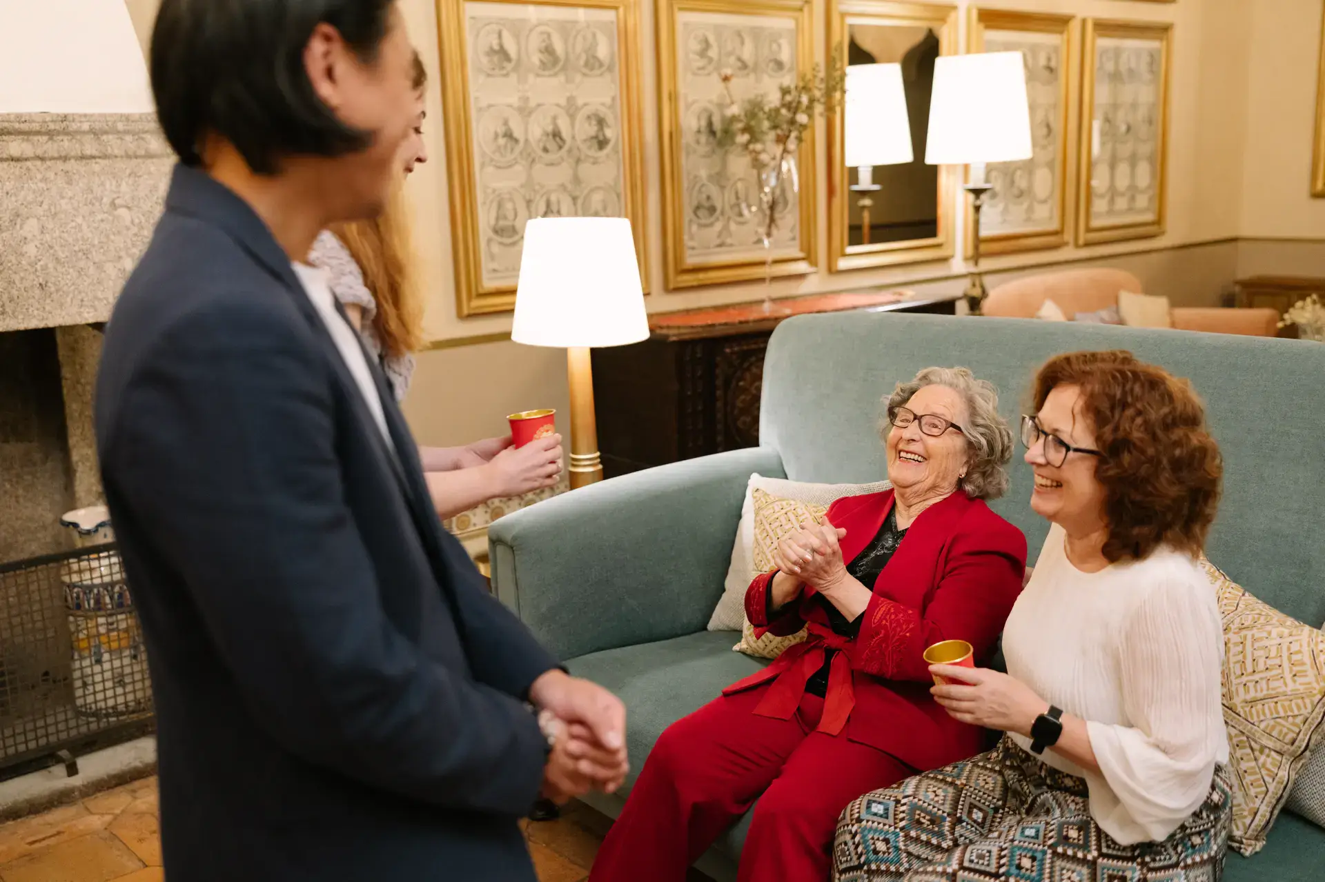 Familiares de Gemma ríen sentadas en el sofá durante la ceremonia del té, en el Parador de Jarandilla