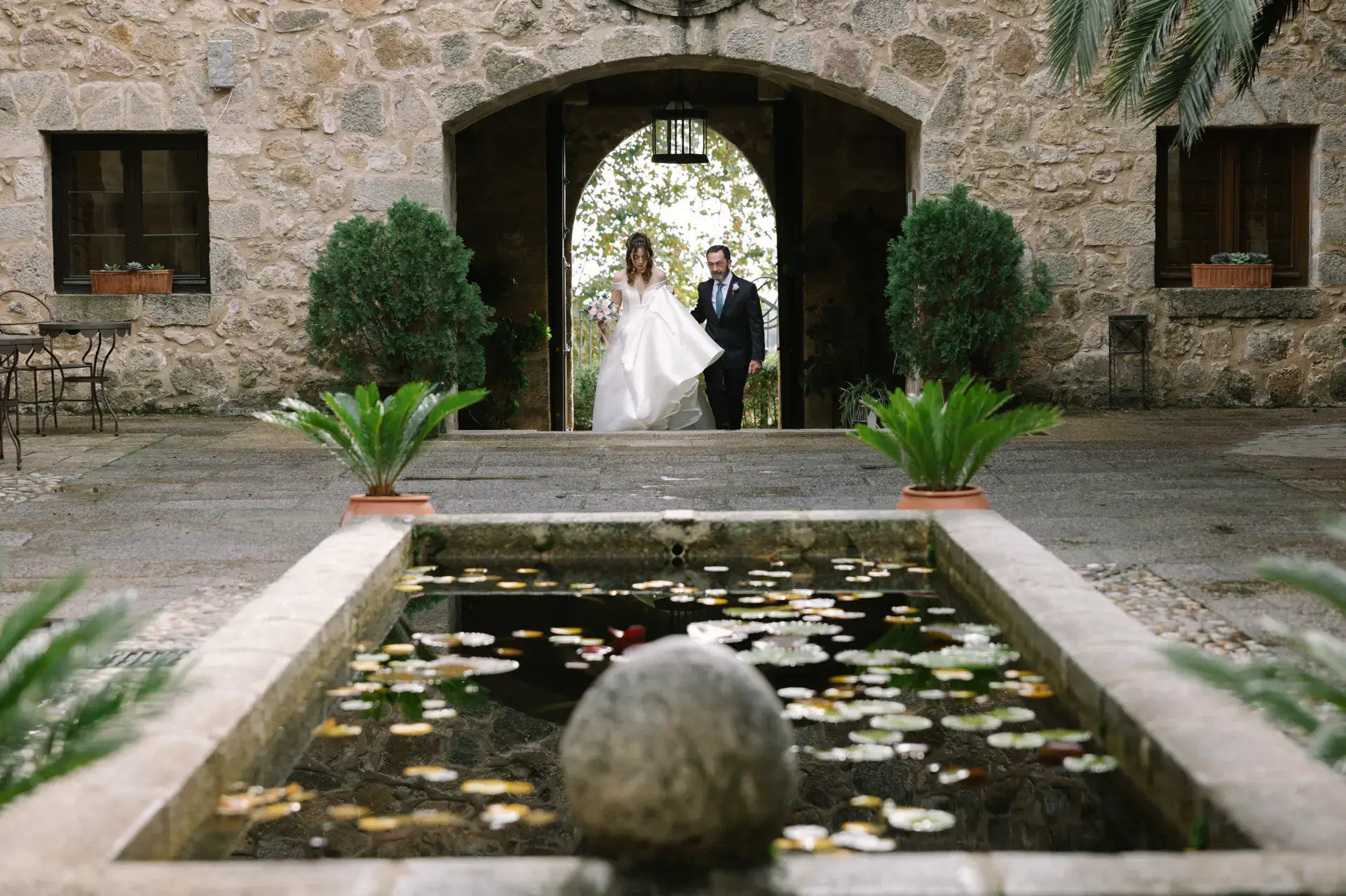 Gemma aparece al fondo del patio del Parador junto a la fuente