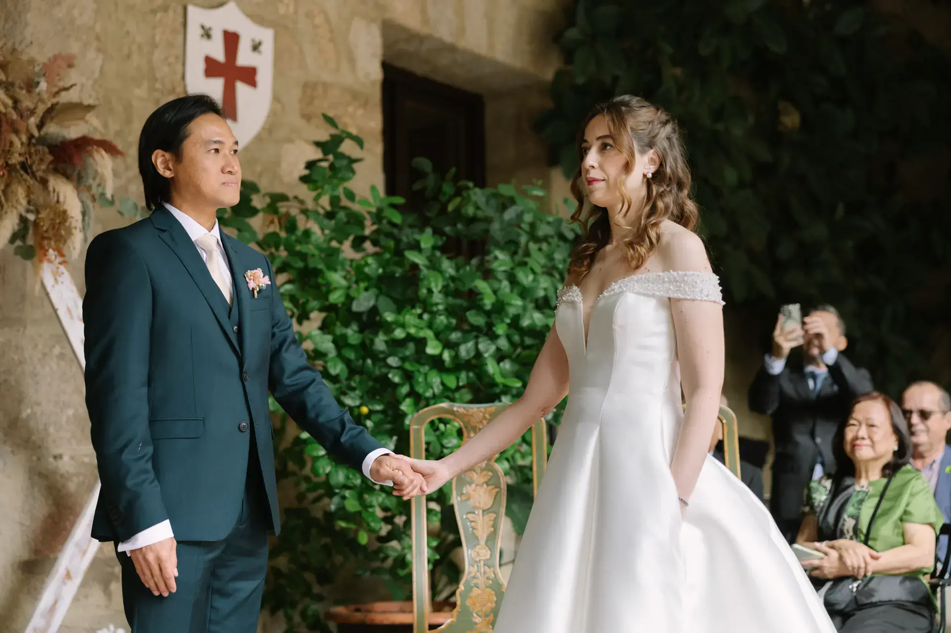 Gemma y Russell de la mano frente a los invitados, en el Parador de Jarandilla