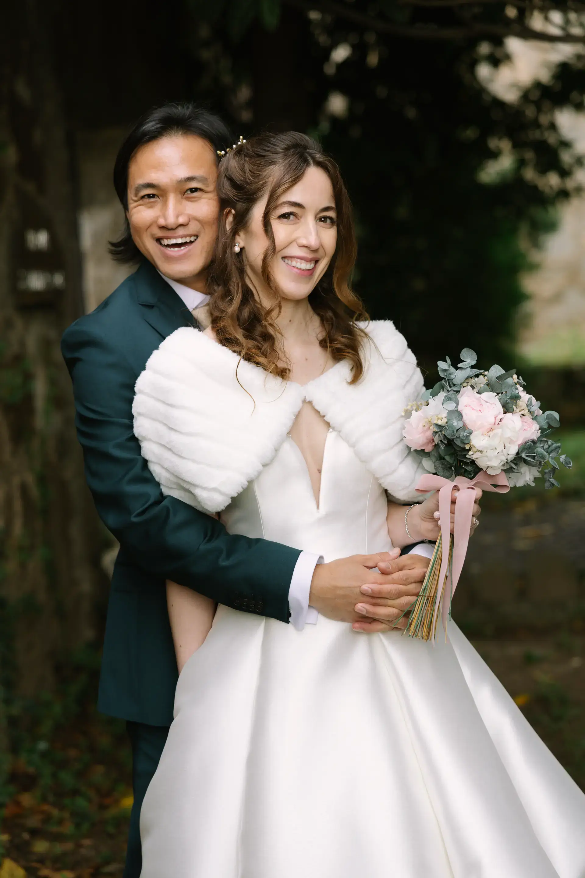 Russell abraza a Gemma por detrás con su ramo de flores, en el Parador de Jarandilla