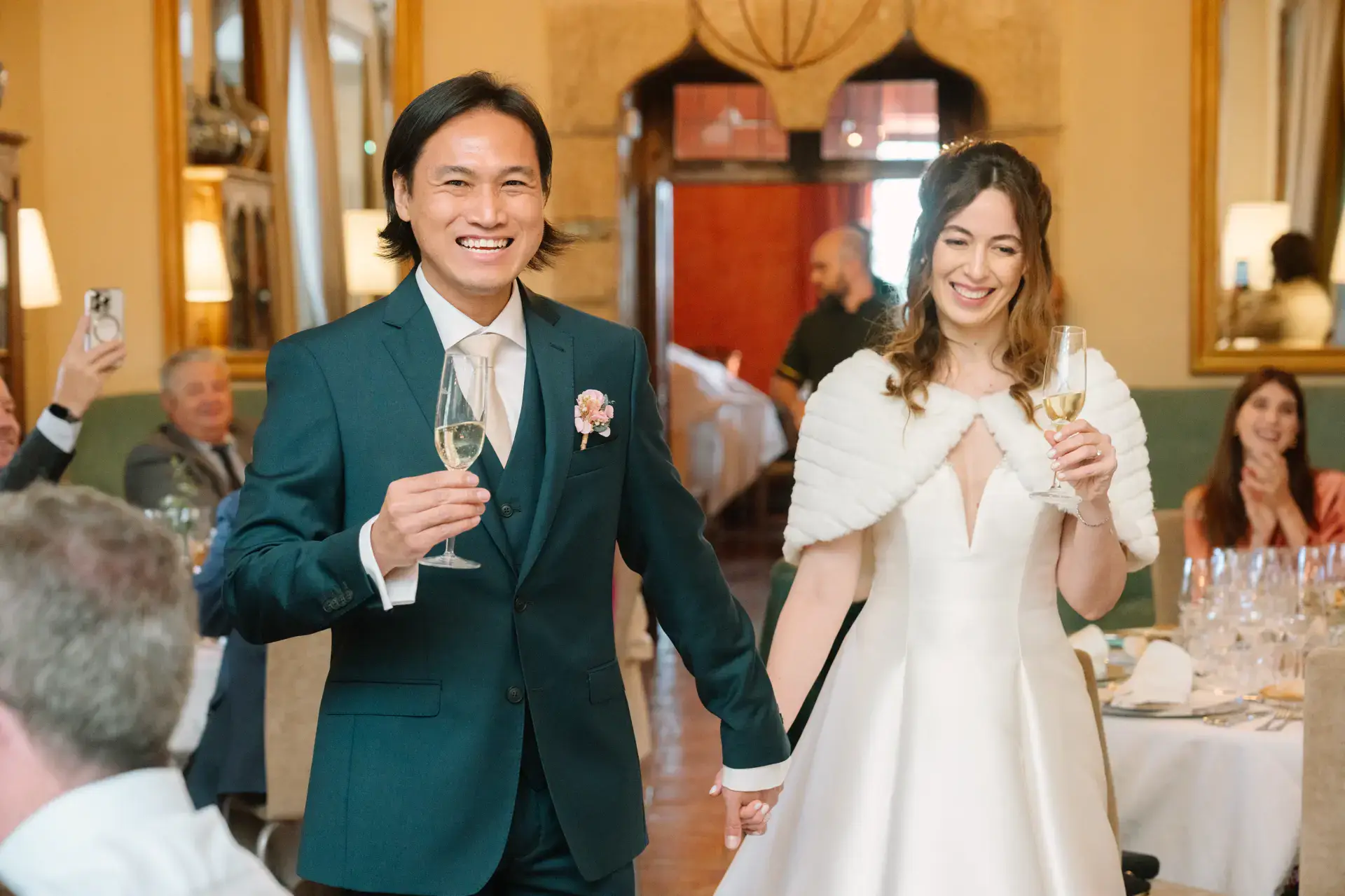 Gemma y Russell entran sonrientes al banquete con sus copas, en el Parador de Jarandilla