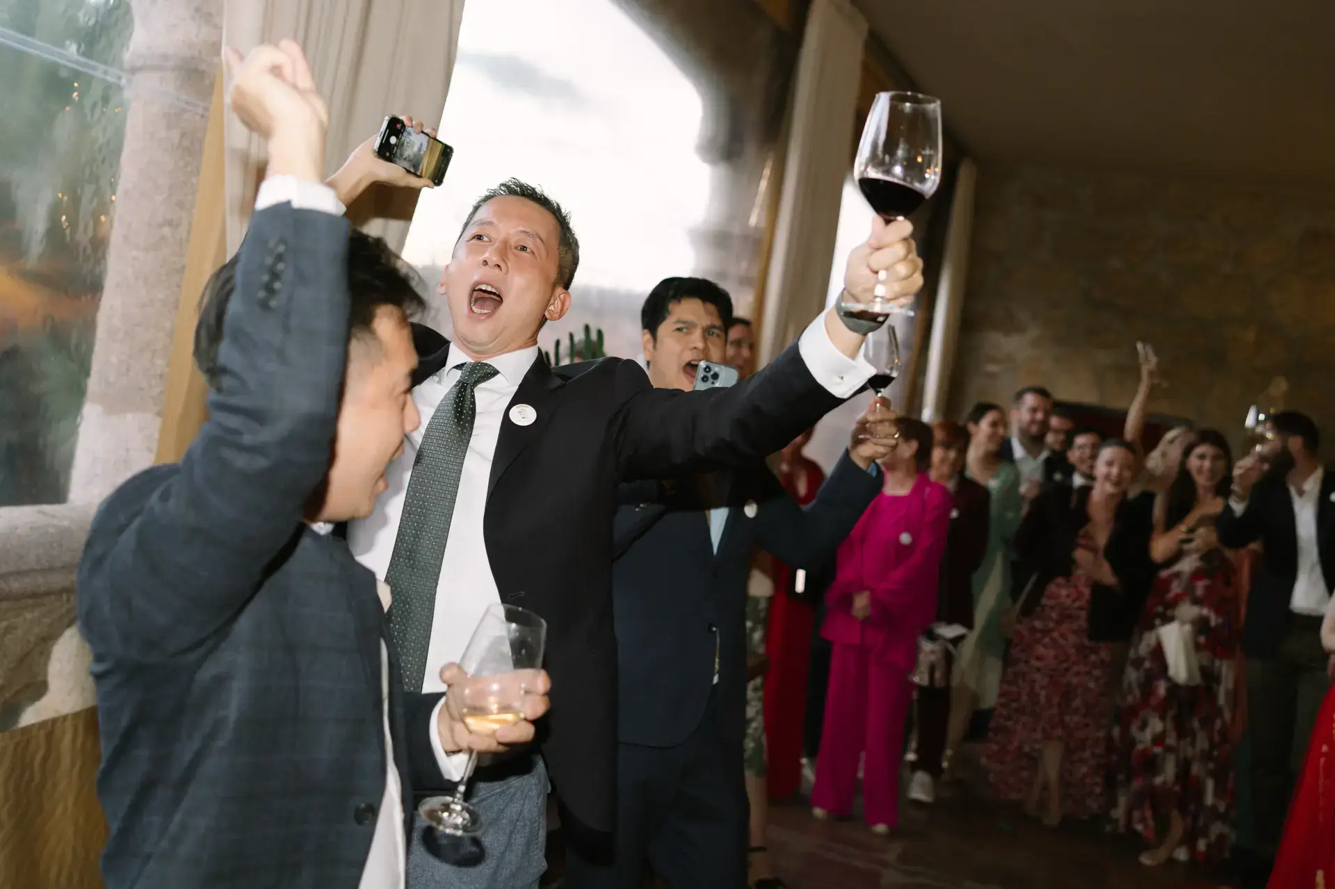 Invitados brindan con las copas en alto en la fiesta, en el Parador de Jarandilla