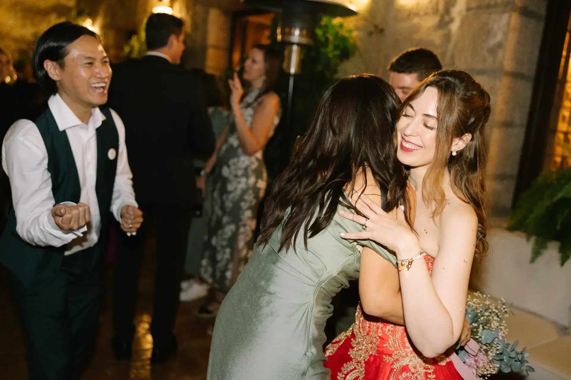 Gemma abraza a una invitada mientras Russell aplaude, en el Parador de Jarandilla