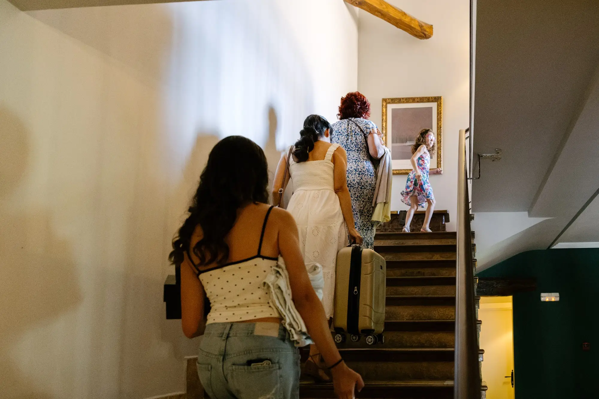 Invitadas suben las escaleras del hotel con su maleta, en el Hotel Ruta Imperial de Jarandilla