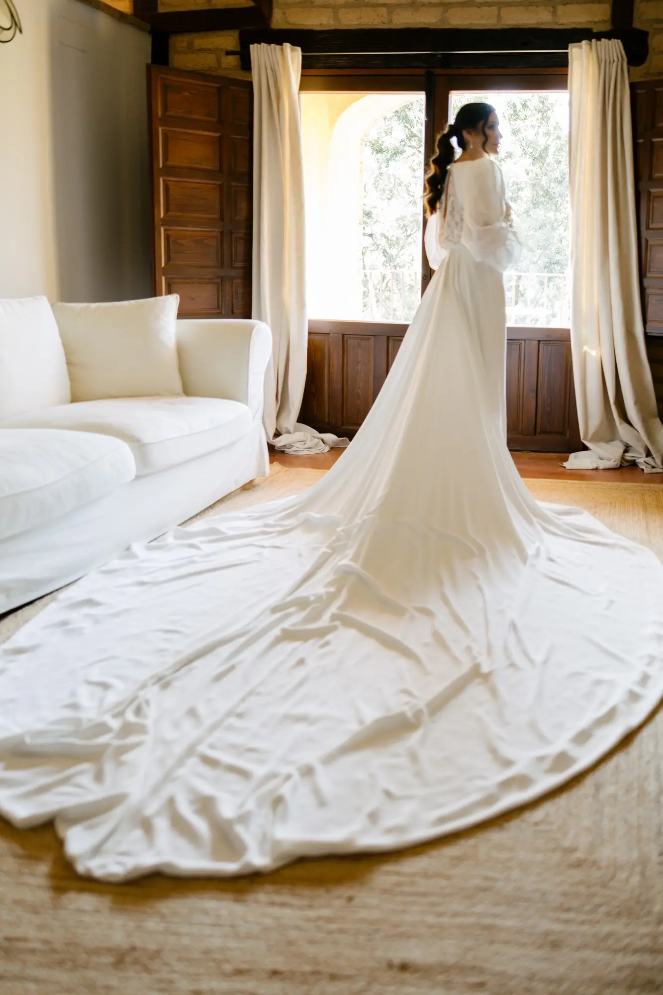 Lara junto a la ventana, con la cola del vestido extendida en el suelo, en el Hotel Ruta Imperial de Jarandilla