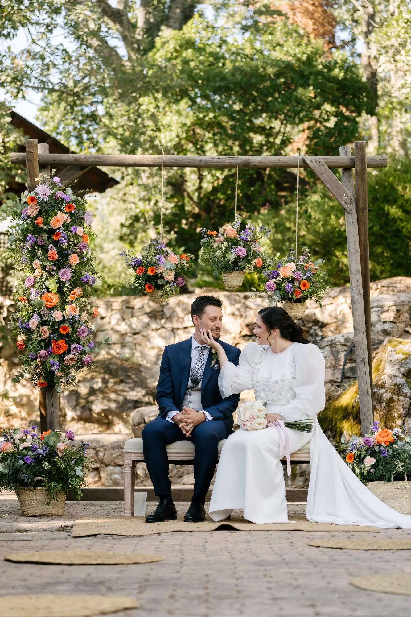 Lara y Rubén en el banco, bajo la pérgola de flores, en el Hotel Ruta Imperial de Jarandilla