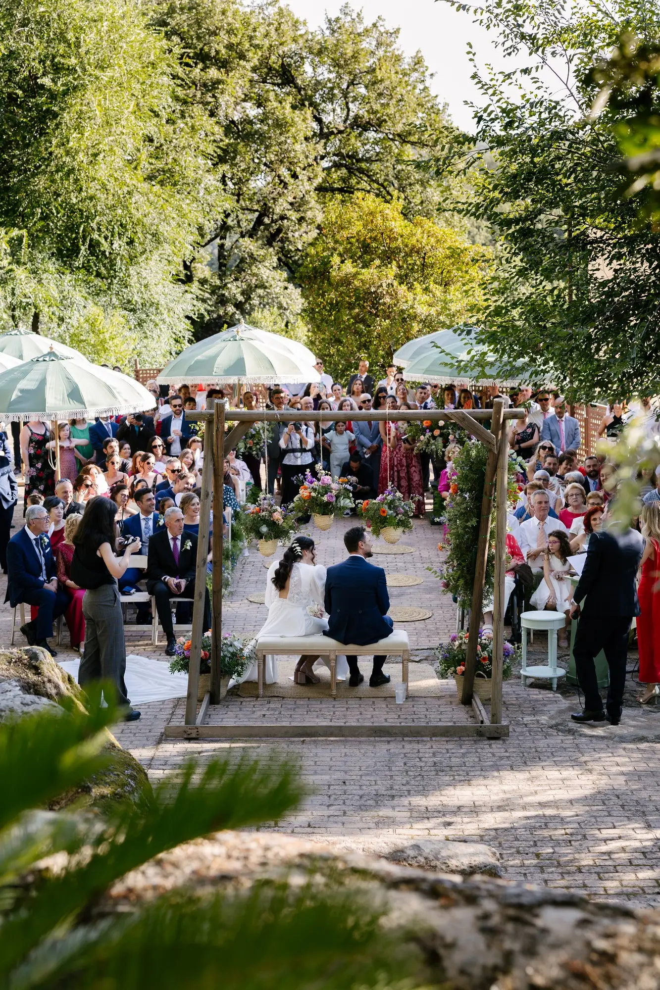 La ceremonia vista desde detrás de la pérgola, con los invitados al fondo, en el Hotel Ruta Imperial de Jarandilla