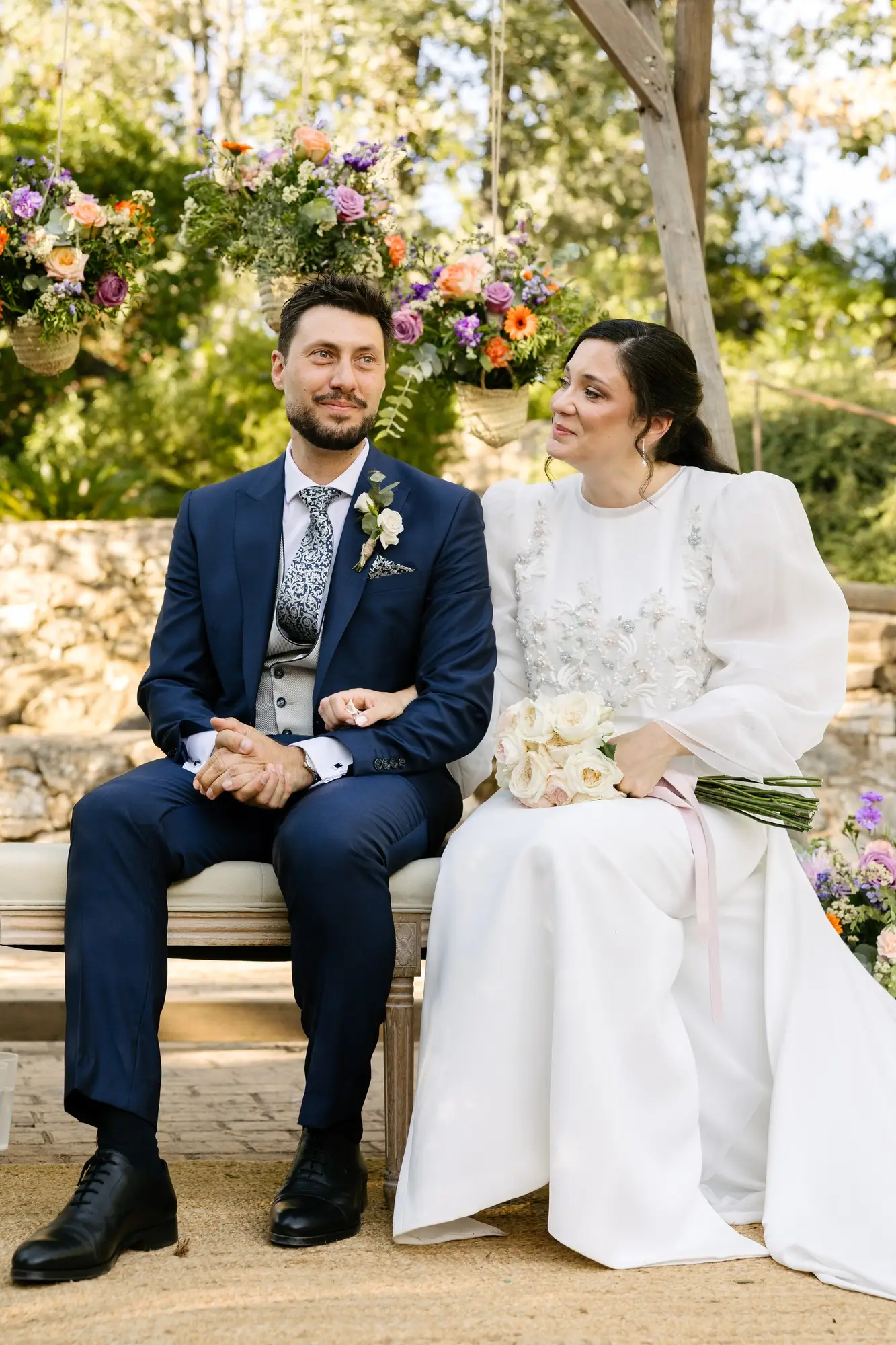 Lara y Rubén de la mano en el banco de la ceremonia, en el Hotel Ruta Imperial de Jarandilla