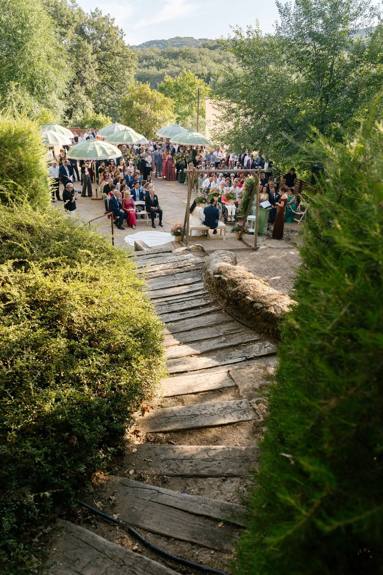 Camino de madera que baja hacia la ceremonia en el jardín del hotel, en el Hotel Ruta Imperial de Jarandilla