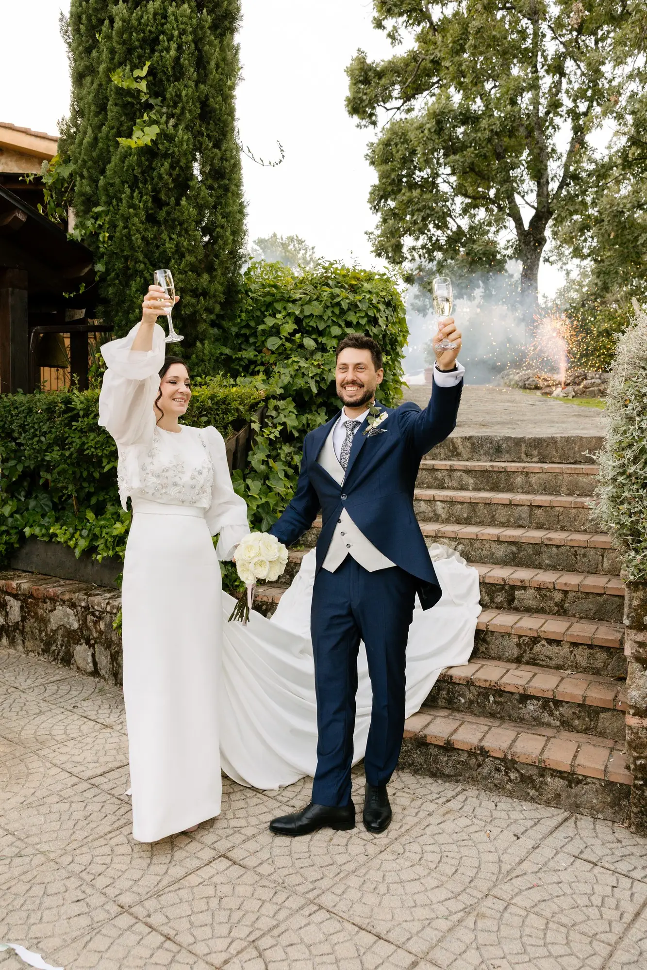 Lara y Rubén levantan los brazos en las escaleras del jardín, en el Hotel Ruta Imperial de Jarandilla