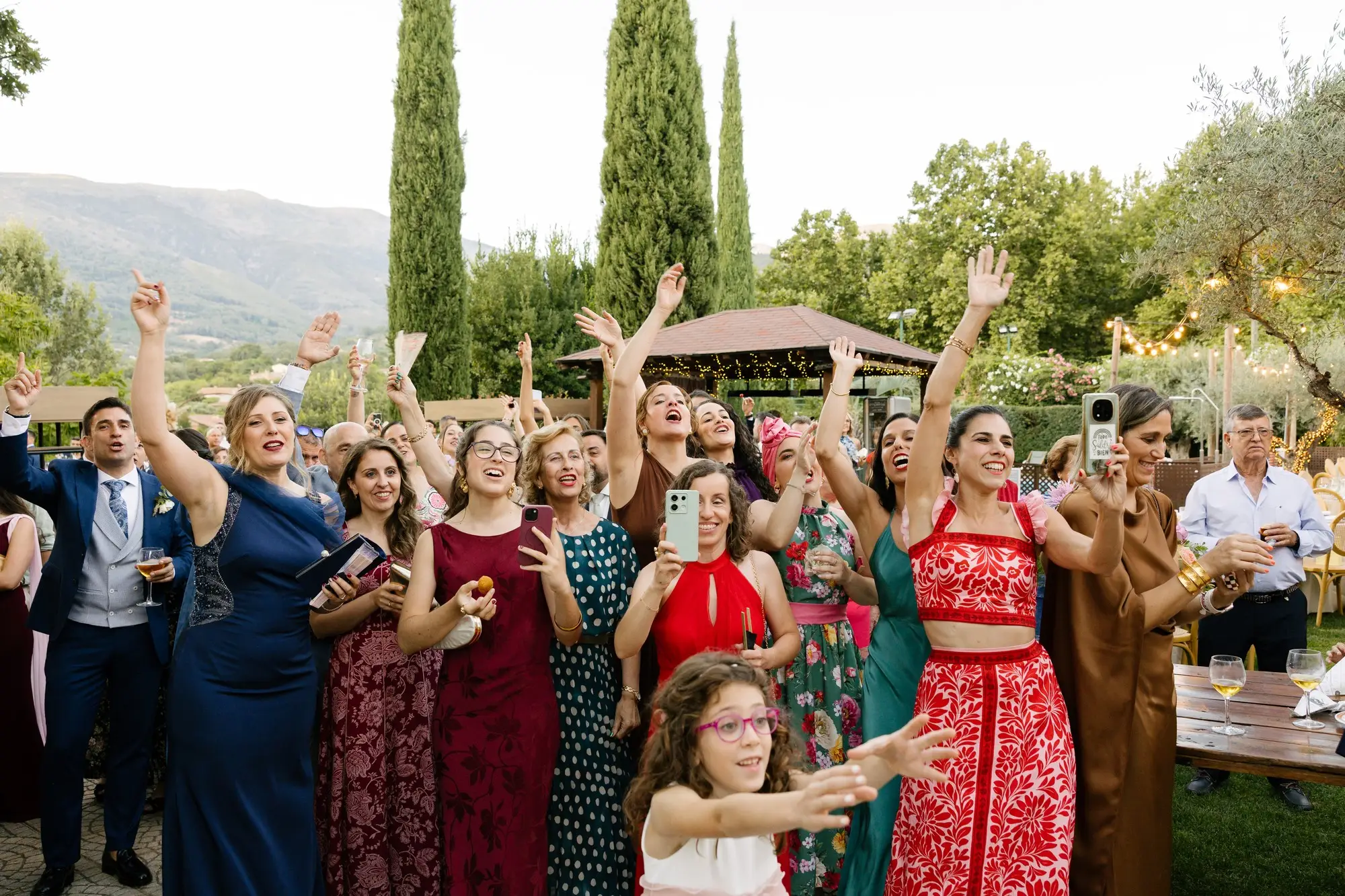 Invitadas levantan los brazos en el jardín, con las montañas de La Vera detrás, en el Hotel Ruta Imperial de Jarandilla