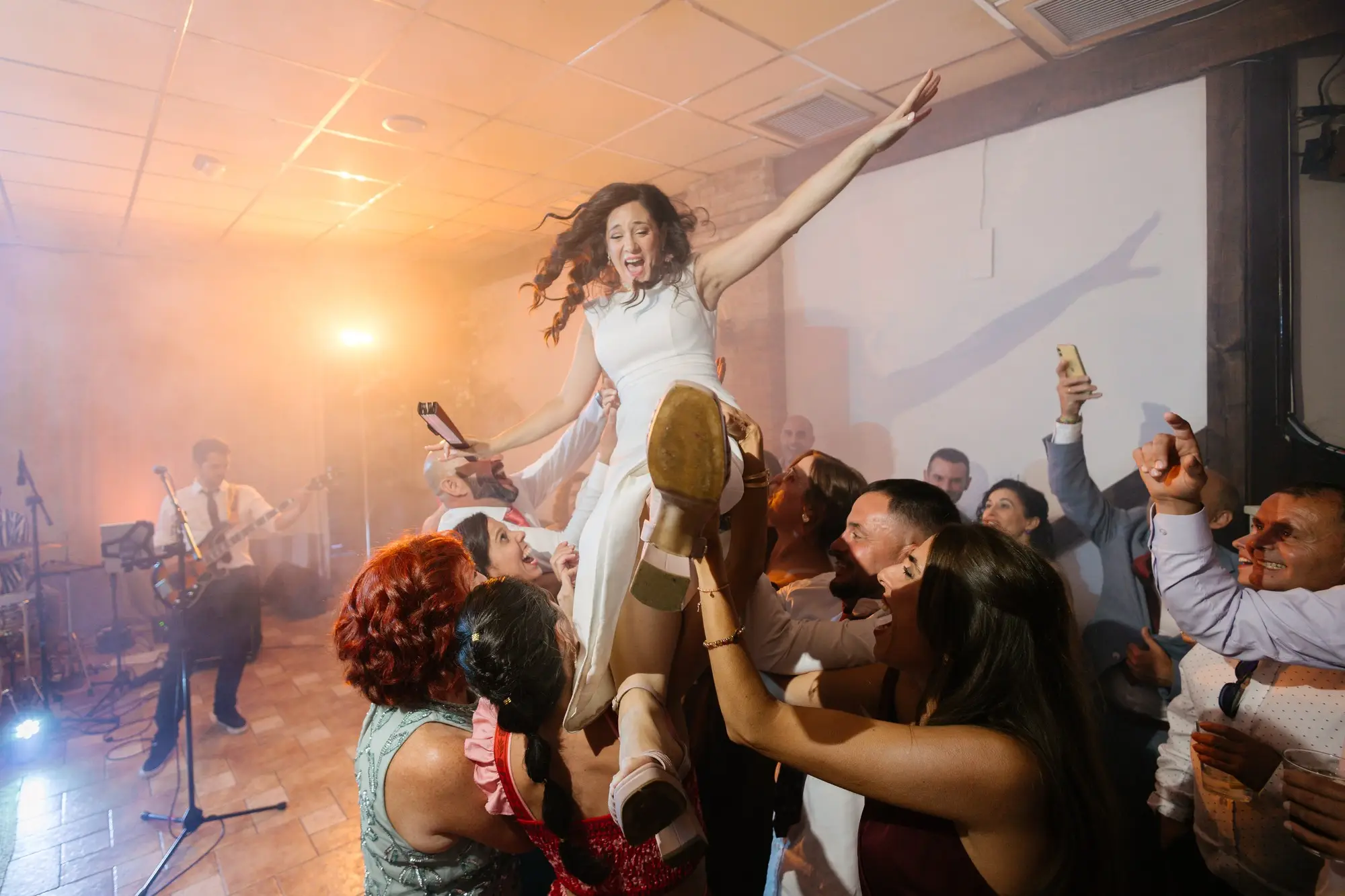 Los invitados levantan a Lara entre el humo y la luz naranja, en el Hotel Ruta Imperial de Jarandilla