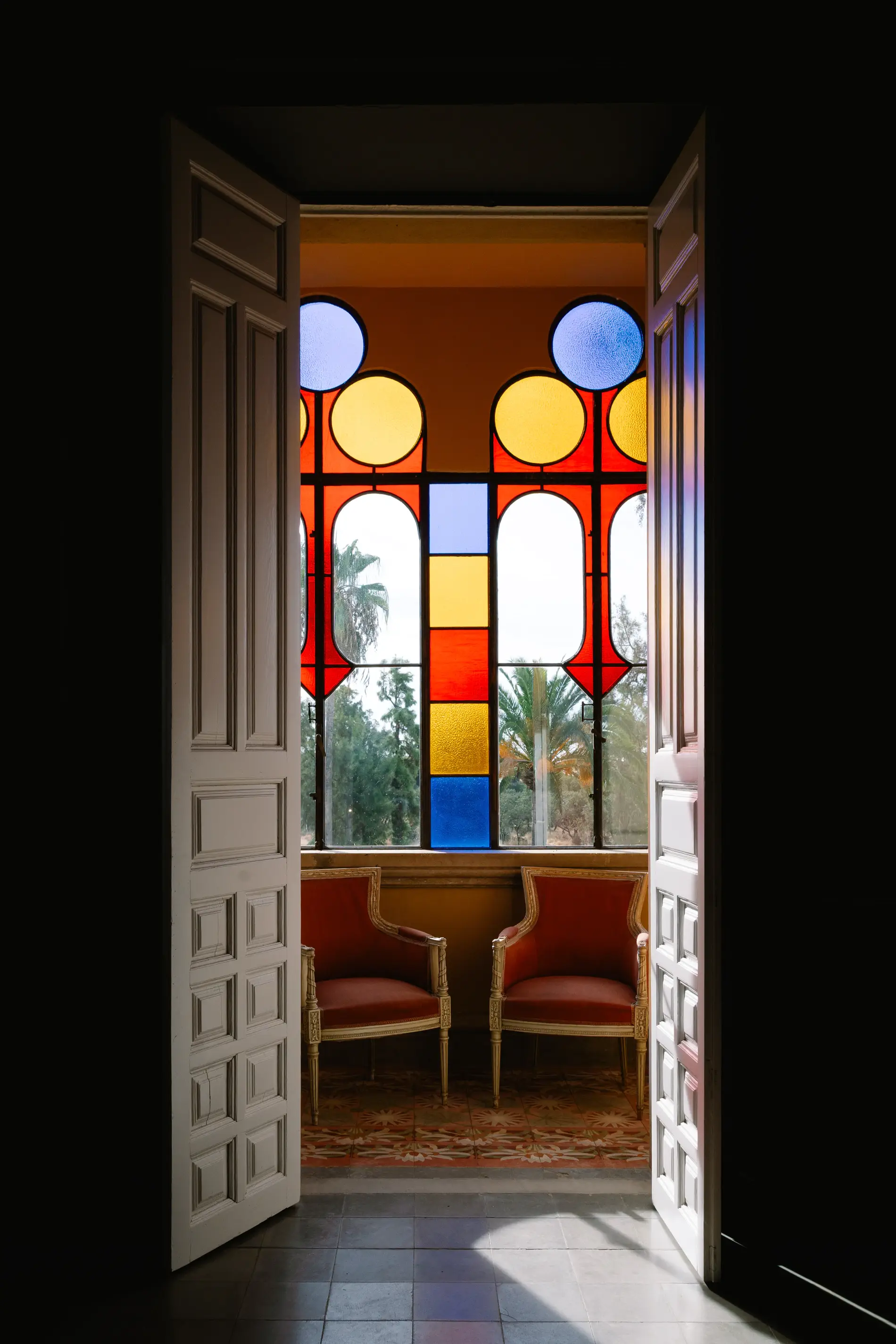 Puerta abierta a una sala con vidrieras de colores en Casa Colorada