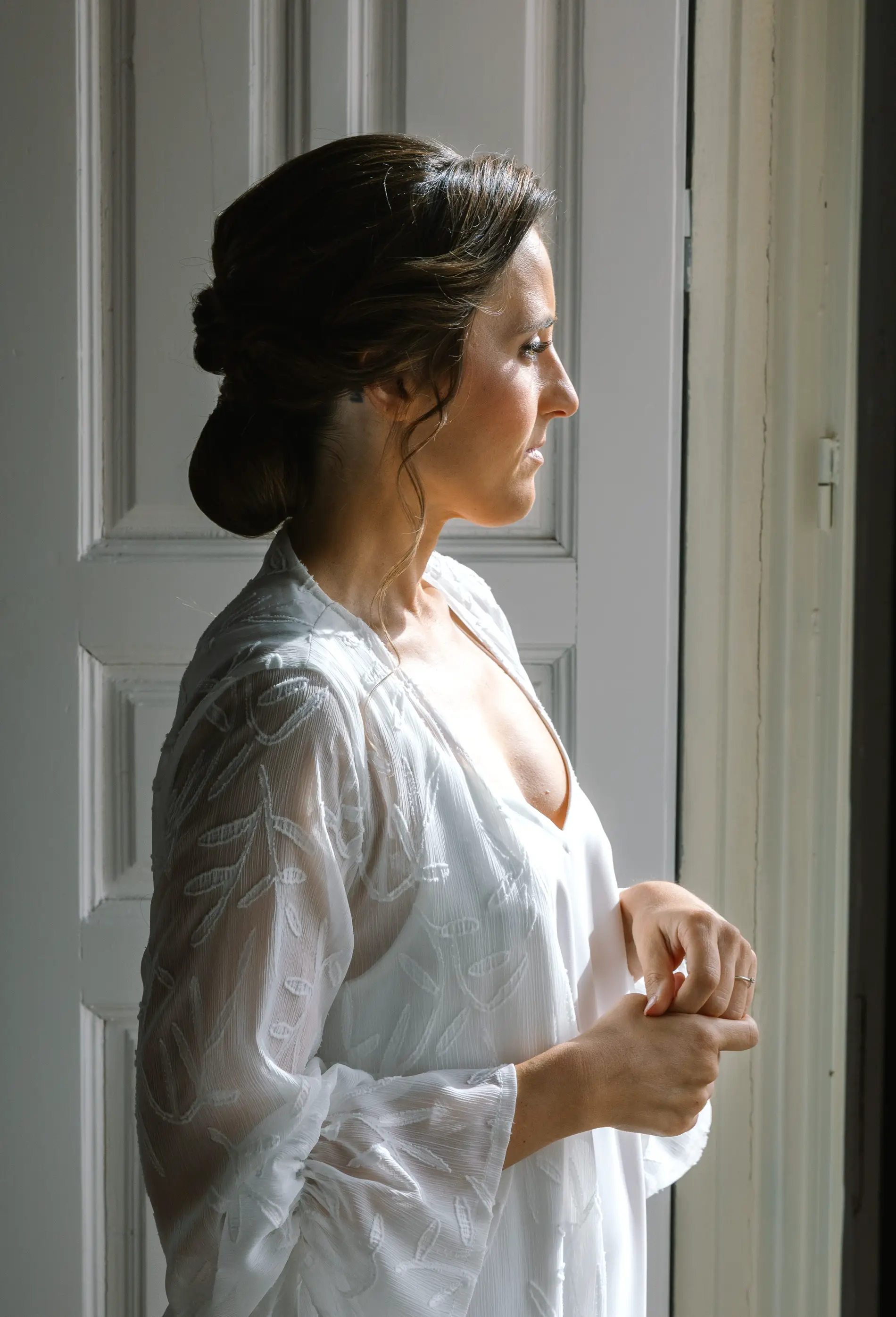María mira por la ventana con su bata de encaje, en Casa Colorada, Badajoz
