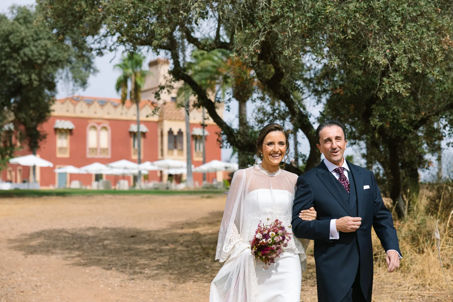 María camina con su padre hacia la ceremonia frente al palacete