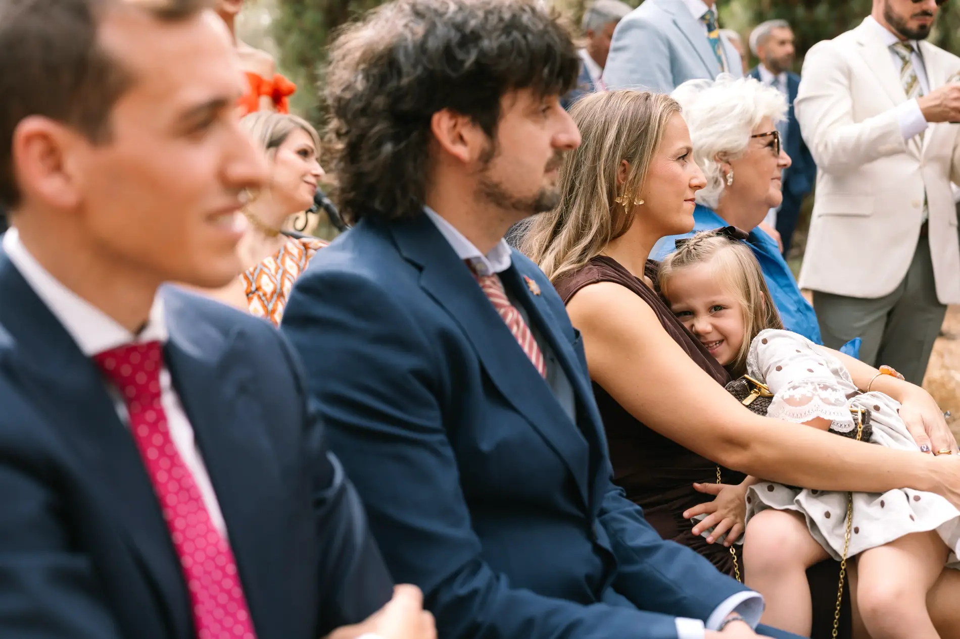 Invitados sonríen sentados durante la ceremonia, en Casa Colorada, Badajoz