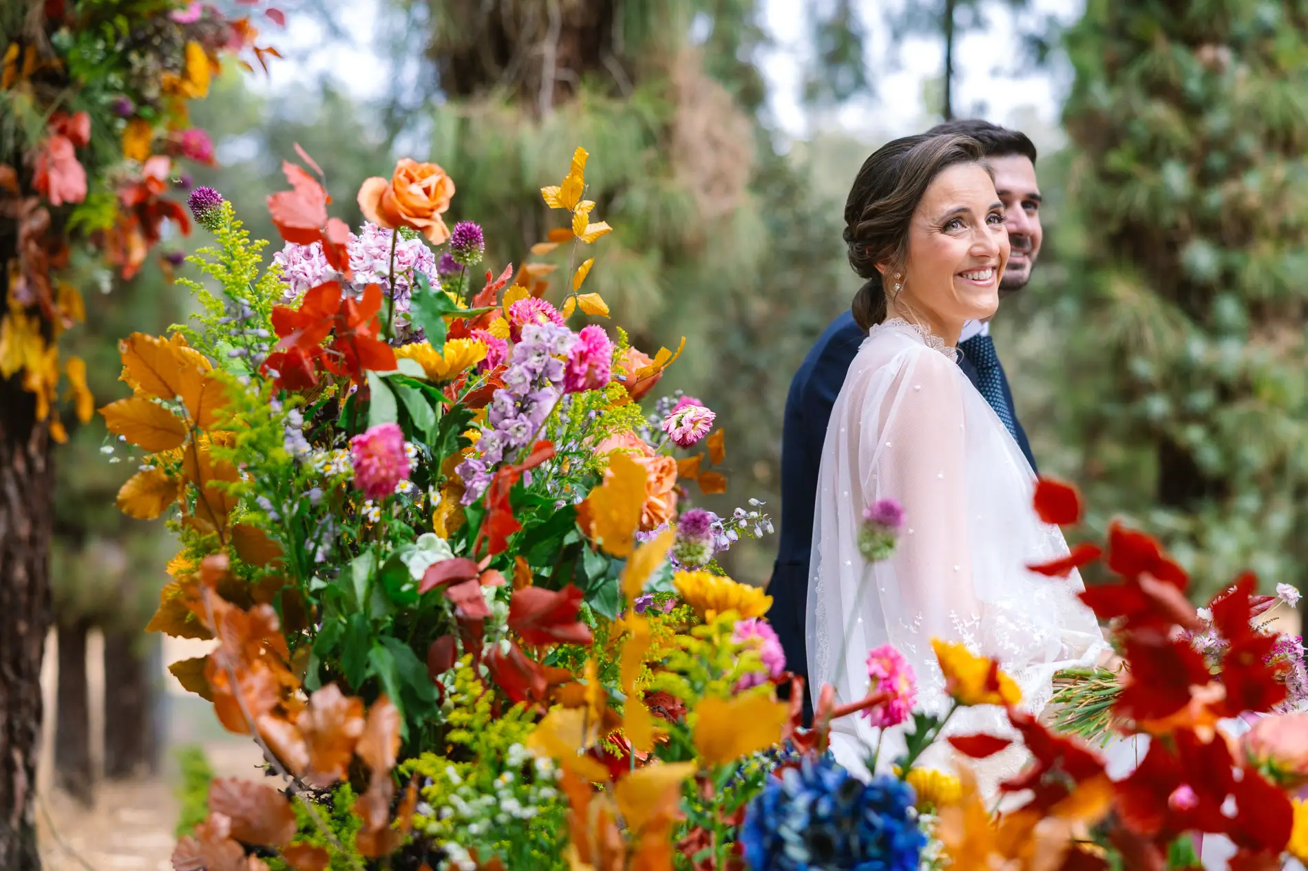 María sonríe entre las flores del altar, en Casa Colorada, Badajoz