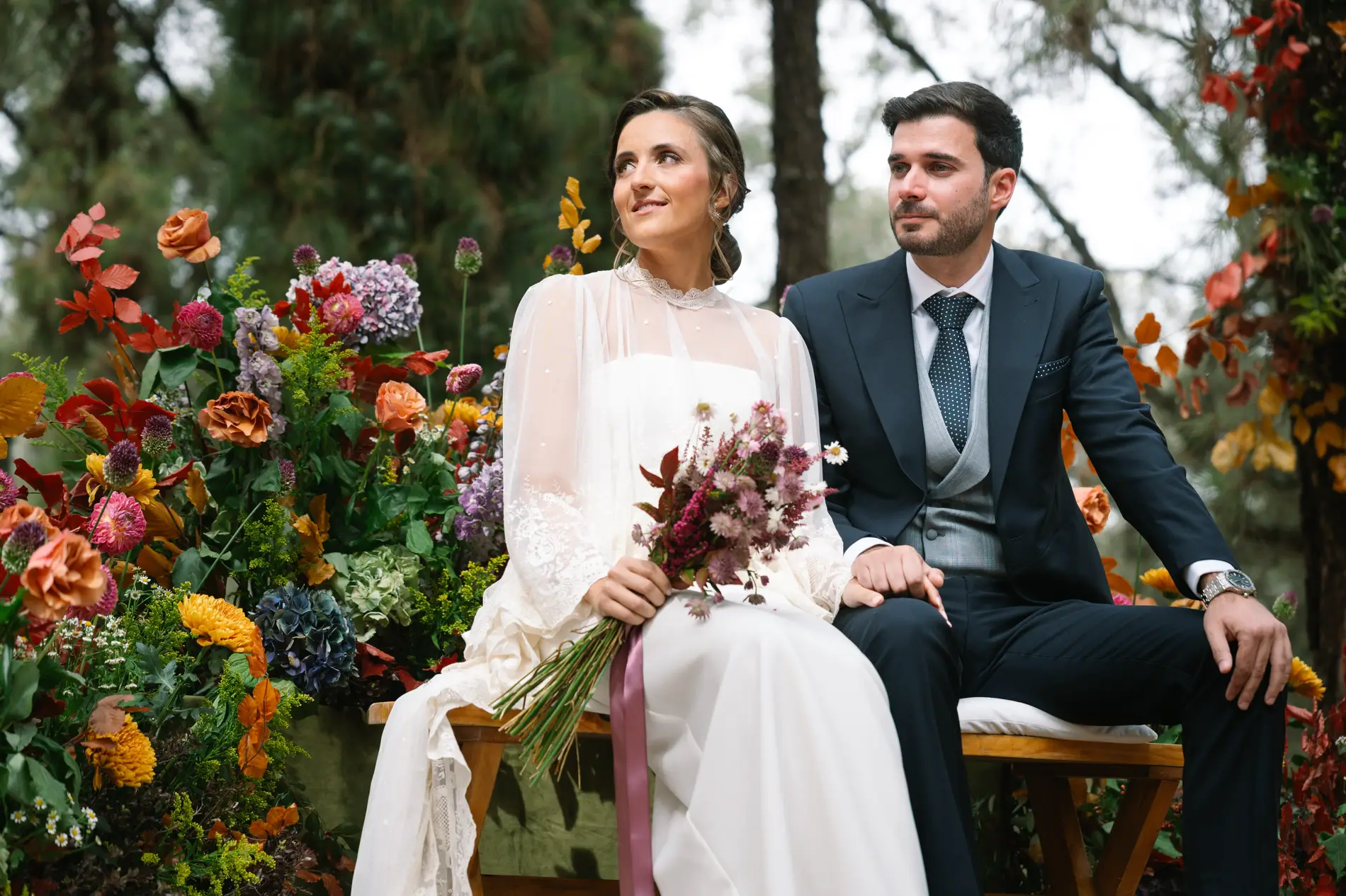 María y Álvaro sentados en el altar mirando a los invitados, en Casa Colorada, Badajoz