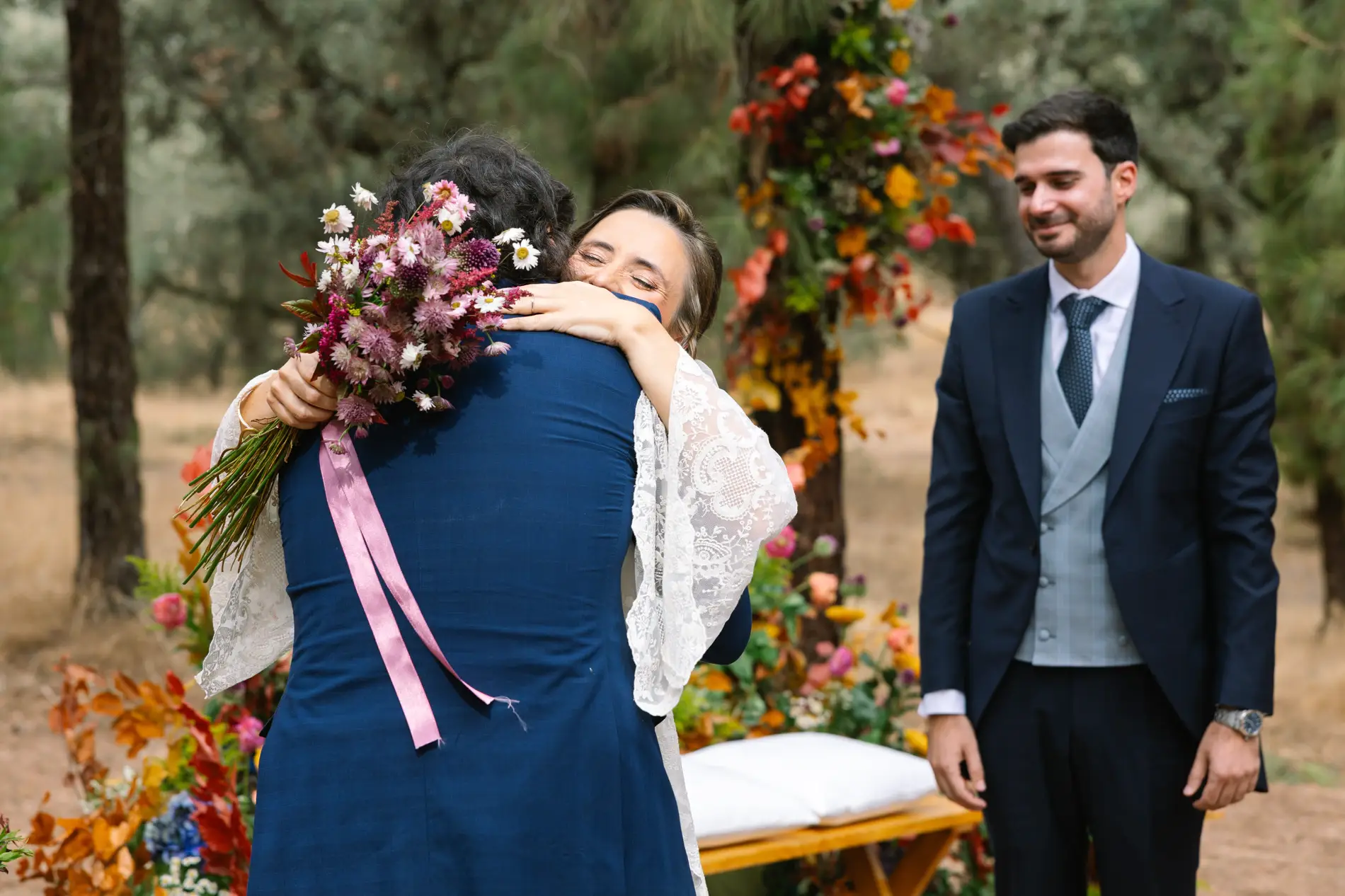 María abraza a un familiar con su ramo en la mano, en Casa Colorada, Badajoz