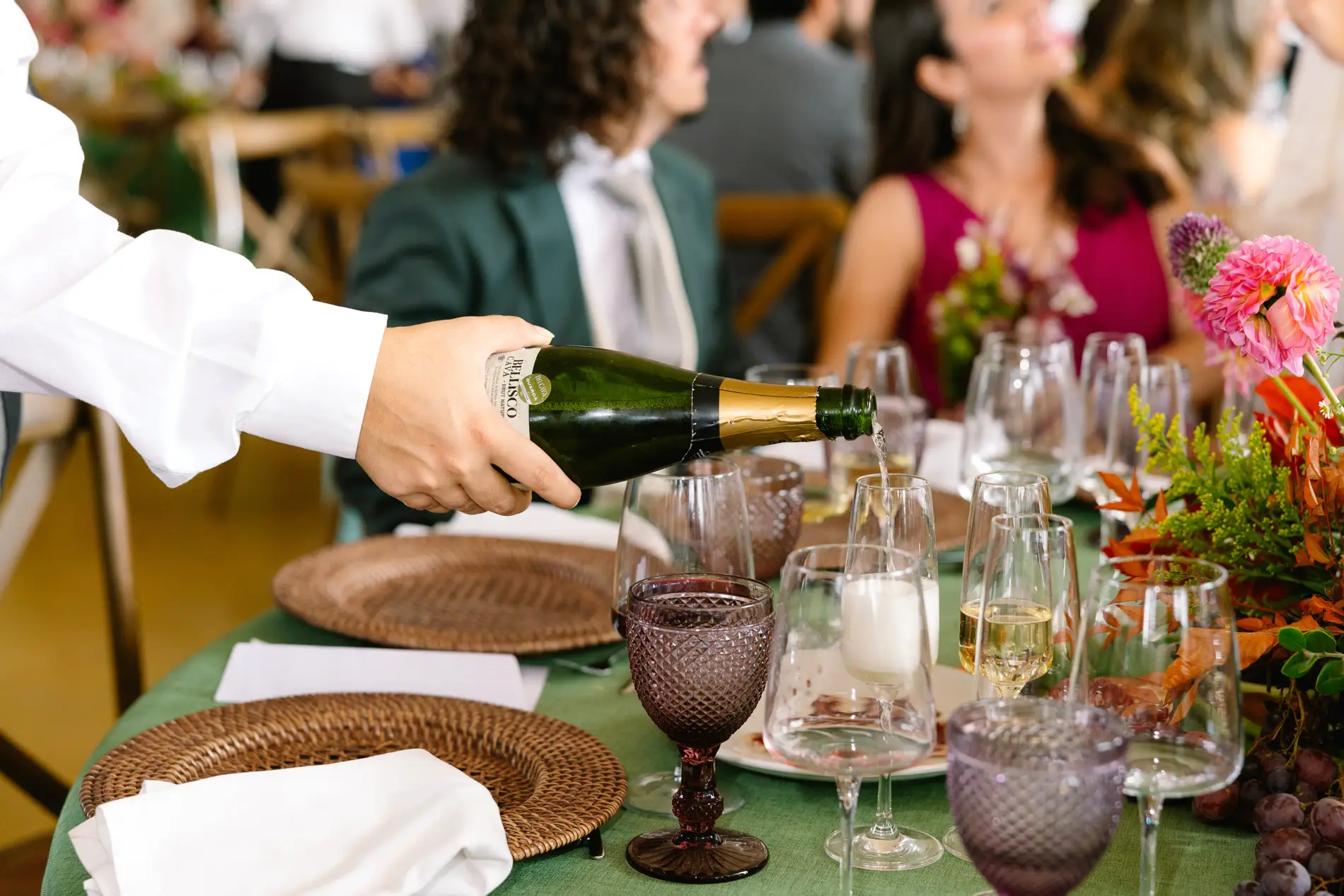 Camarero sirve cava en la mesa con copas de color violeta, en Casa Colorada, Badajoz