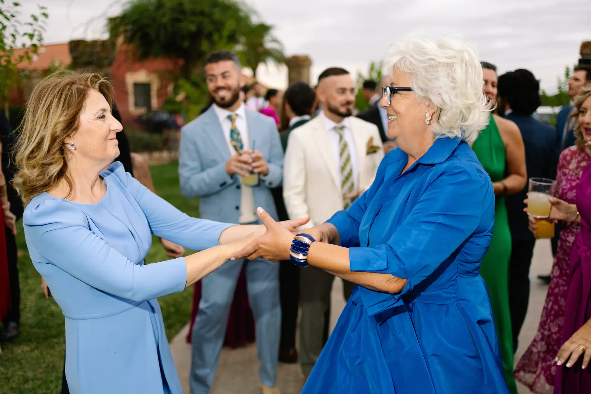 Dos invitadas bailan de la mano en el jardín, en Casa Colorada, Badajoz