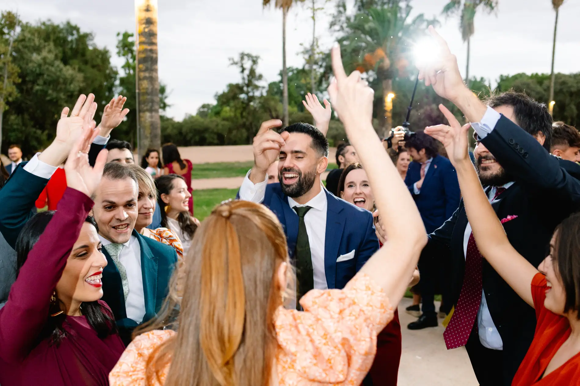 Invitados bailan en corro entre luces del atardecer, en Casa Colorada, Badajoz