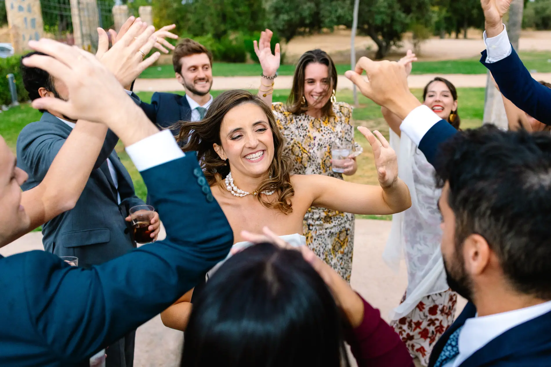 María baila rodeada de amigos con las manos en alto, en Casa Colorada, Badajoz