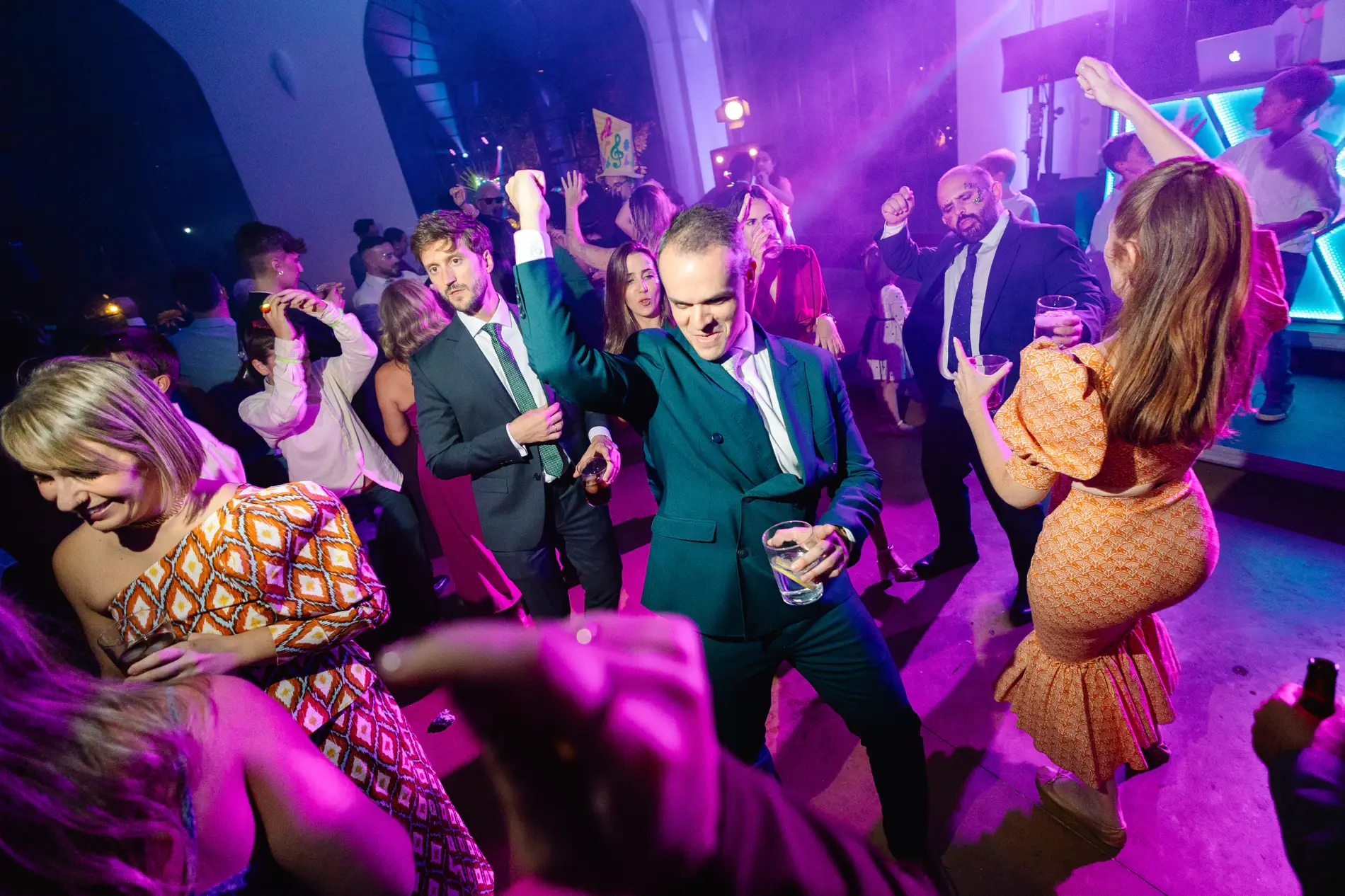 Invitados bailan entre luces moradas al final de la fiesta, en Casa Colorada, Badajoz