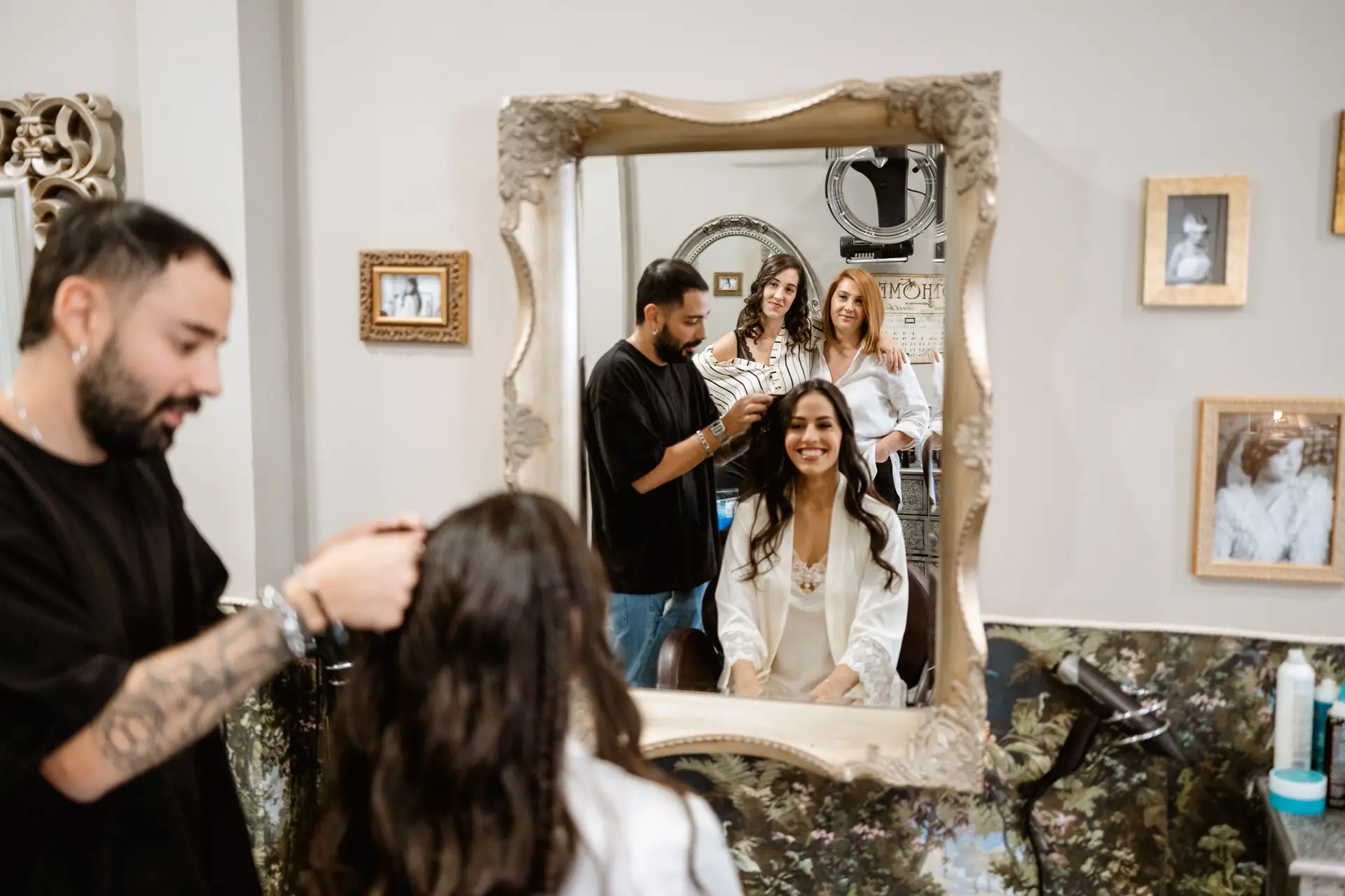 El peluquero peina a la novia, reflejada en un espejo dorado, en Mérida