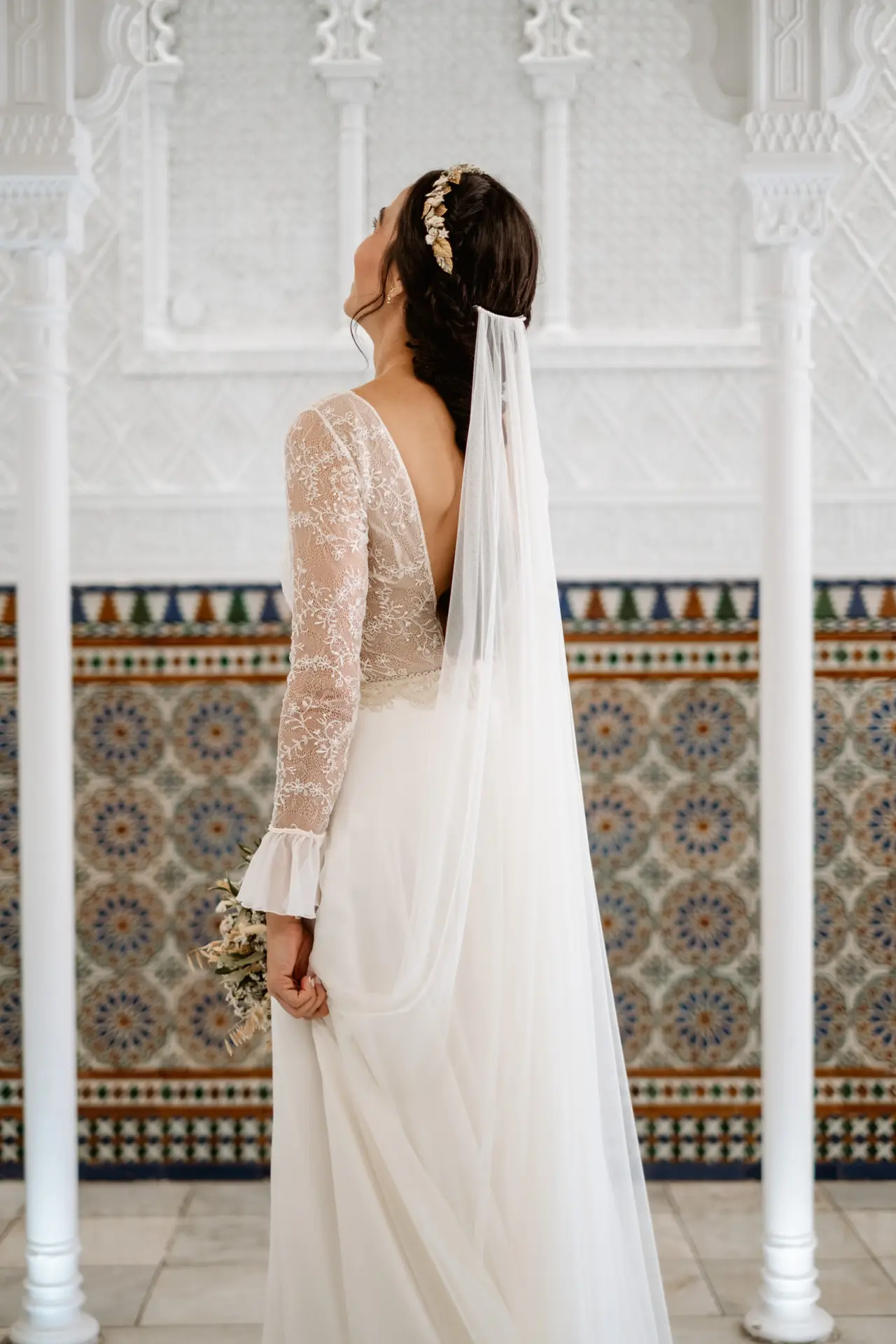 La novia de espaldas, con el velo y el vestido de encaje, en Mérida