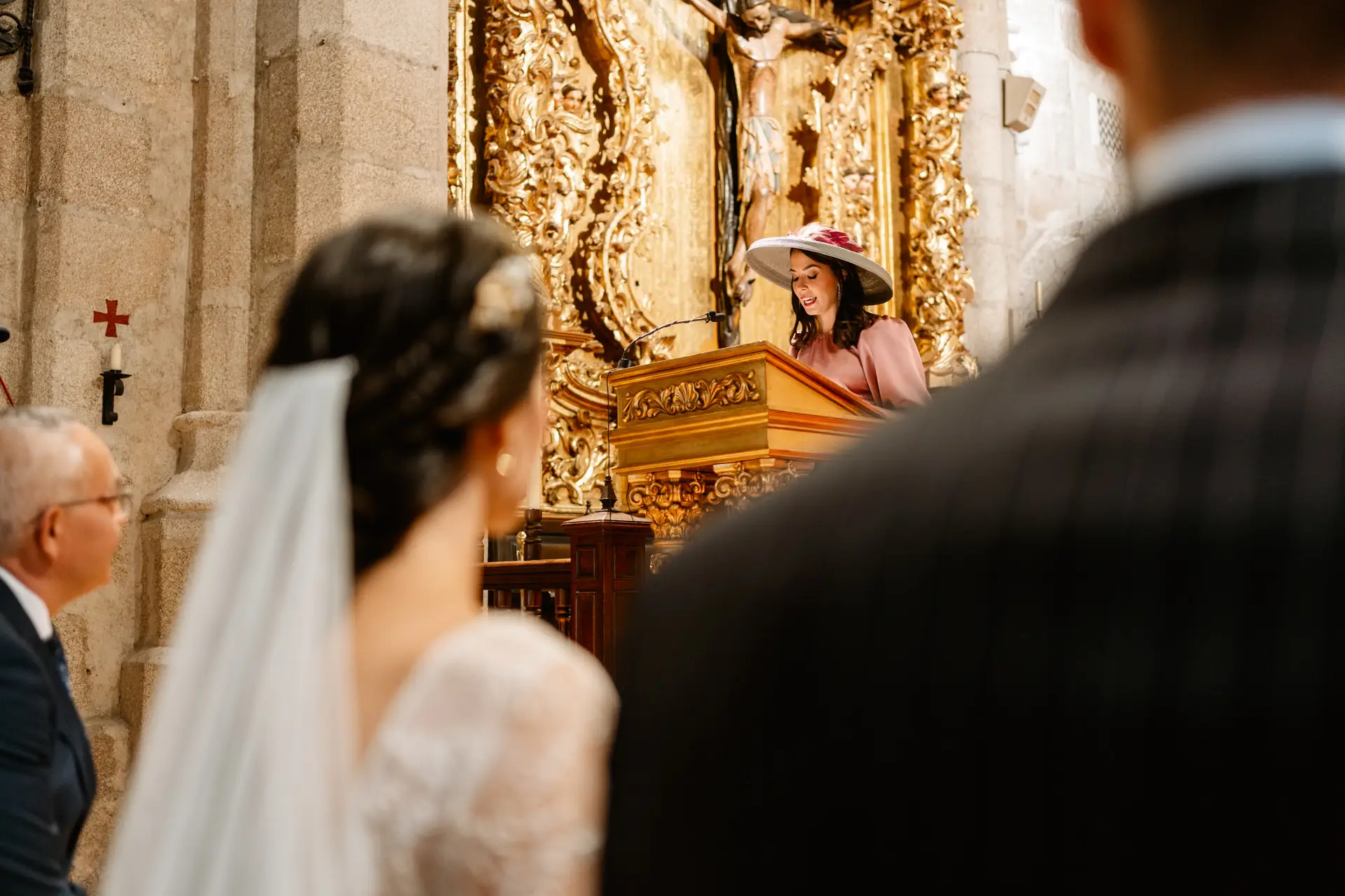 Una invitada lee en el ambón, junto al retablo dorado de la Concatedral, en Mérida