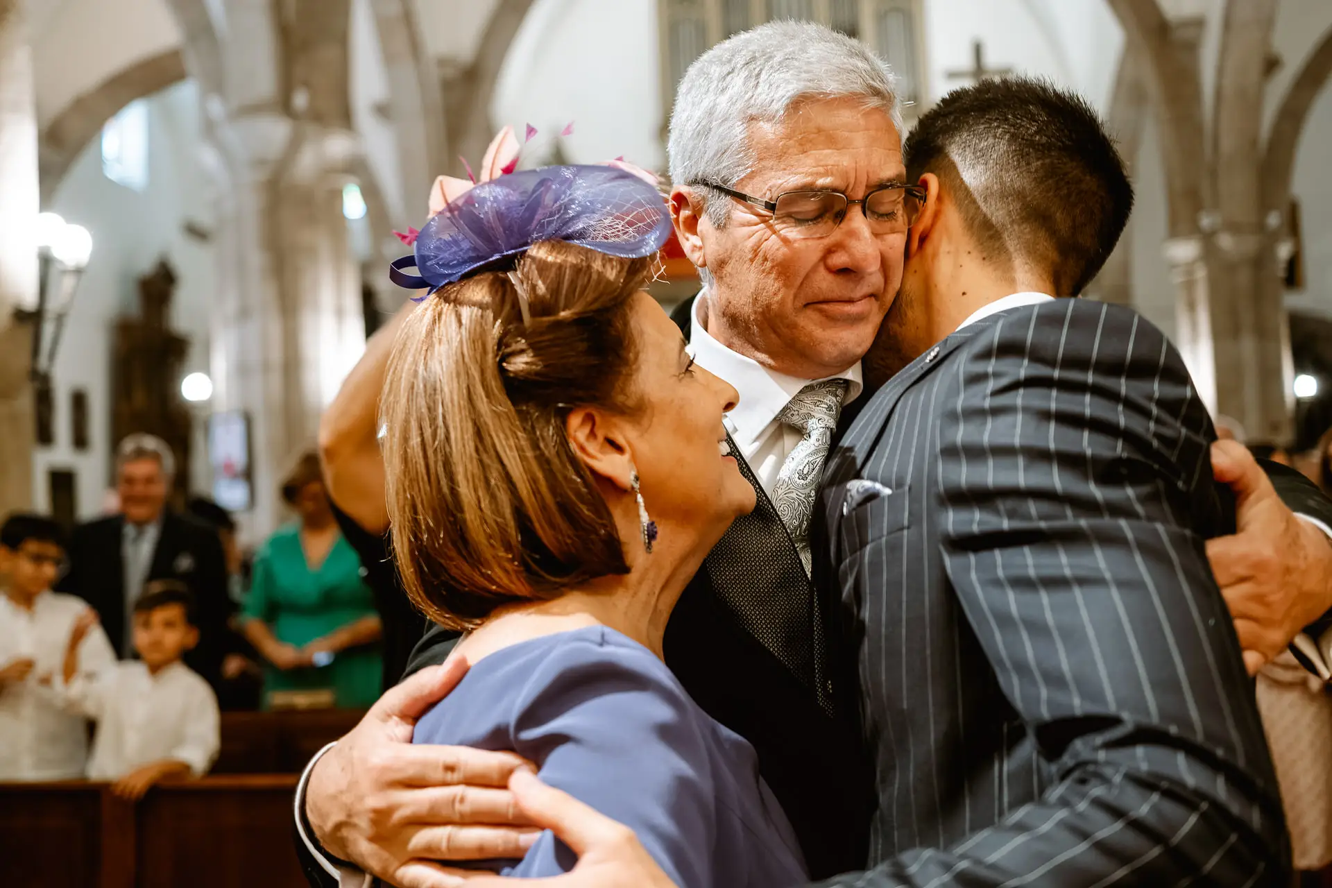 El novio abraza a dos familiares en el altar, en Mérida