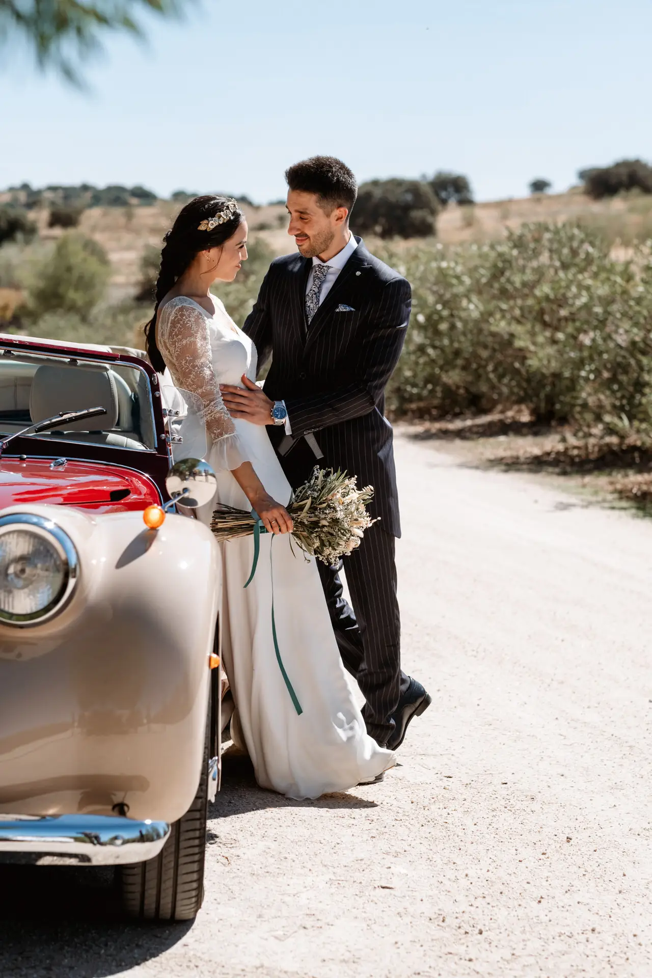 Los novios abrazados junto al coche clásico, en Mérida