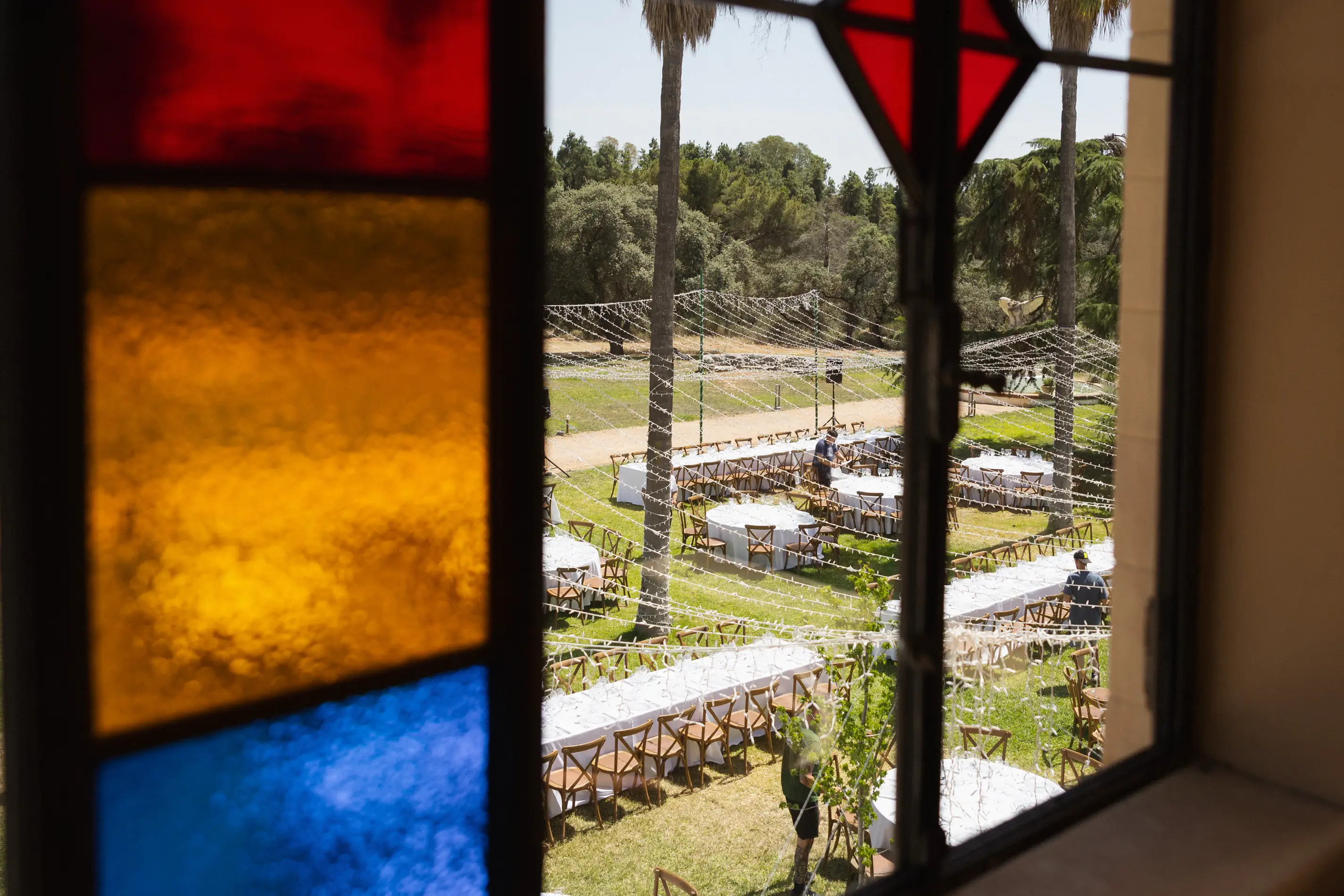 Vidriera de colores con vistas a las mesas del banquete en el jardín de Casa Colorada
