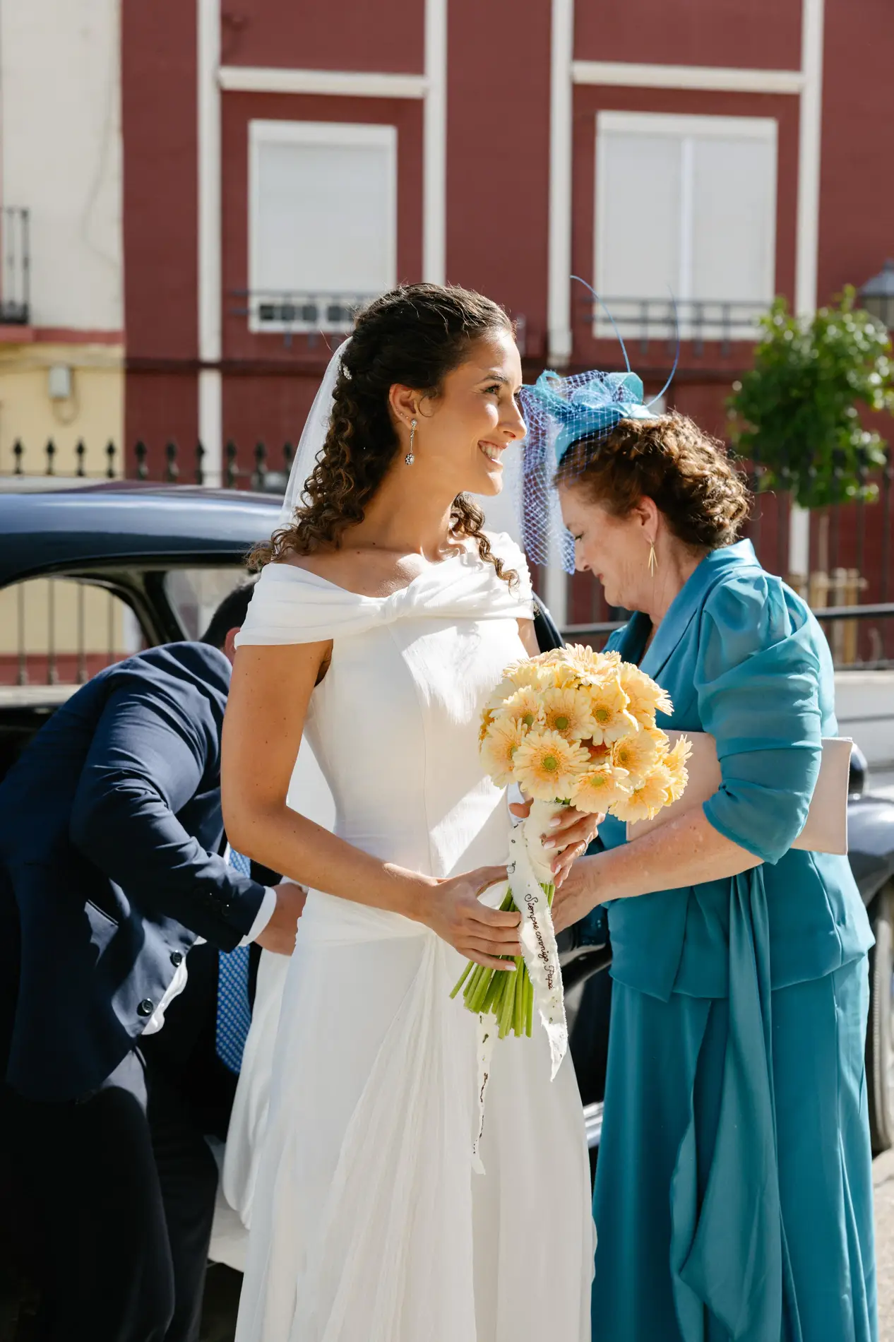 Natalia llega a la iglesia con su ramo de gerberas y saluda a una invitada, en Badajoz