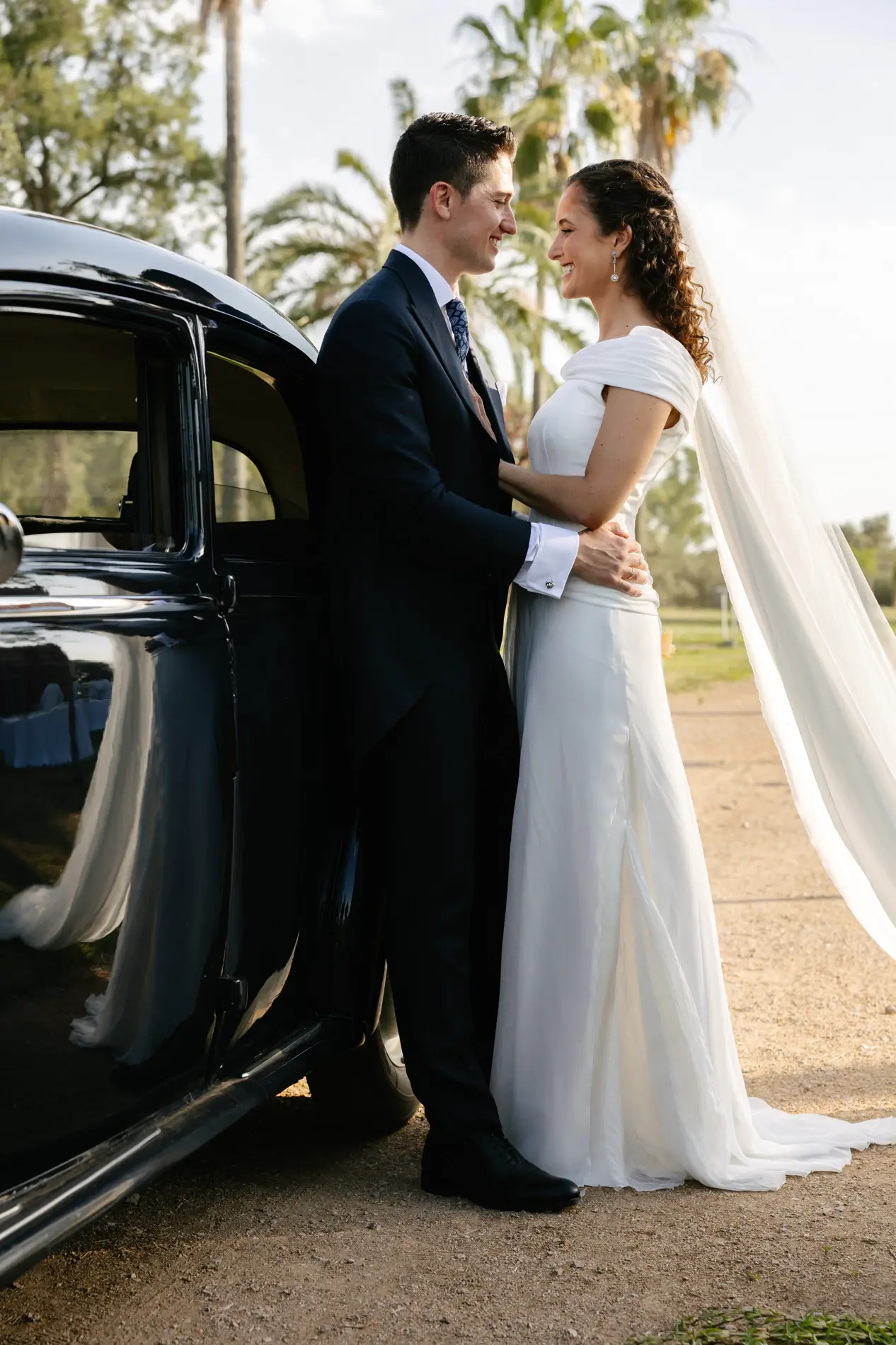 Natalia y Rodrigo junto al coche clásico al atardecer, en Badajoz