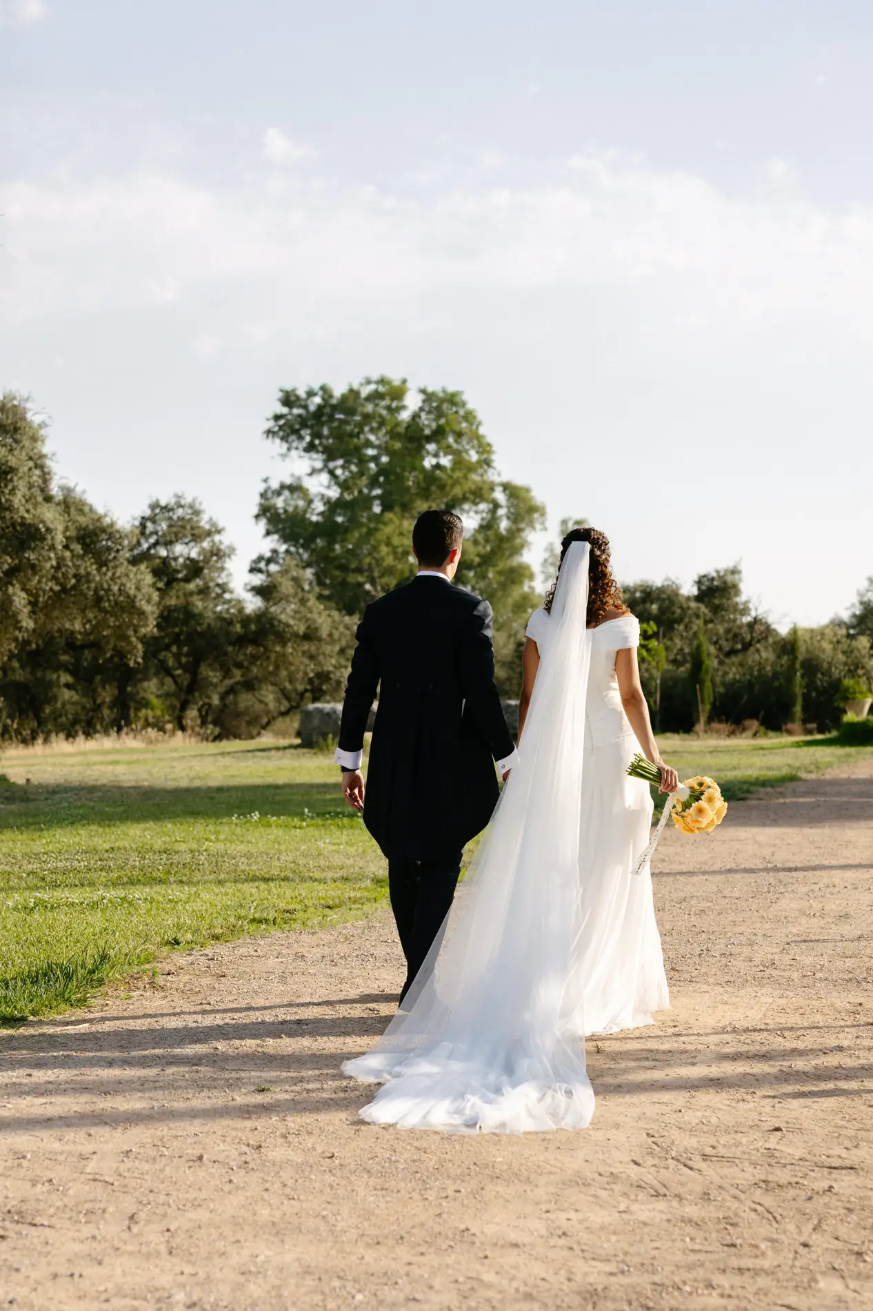 Natalia y Rodrigo caminan de espaldas por un camino de la finca, en Badajoz