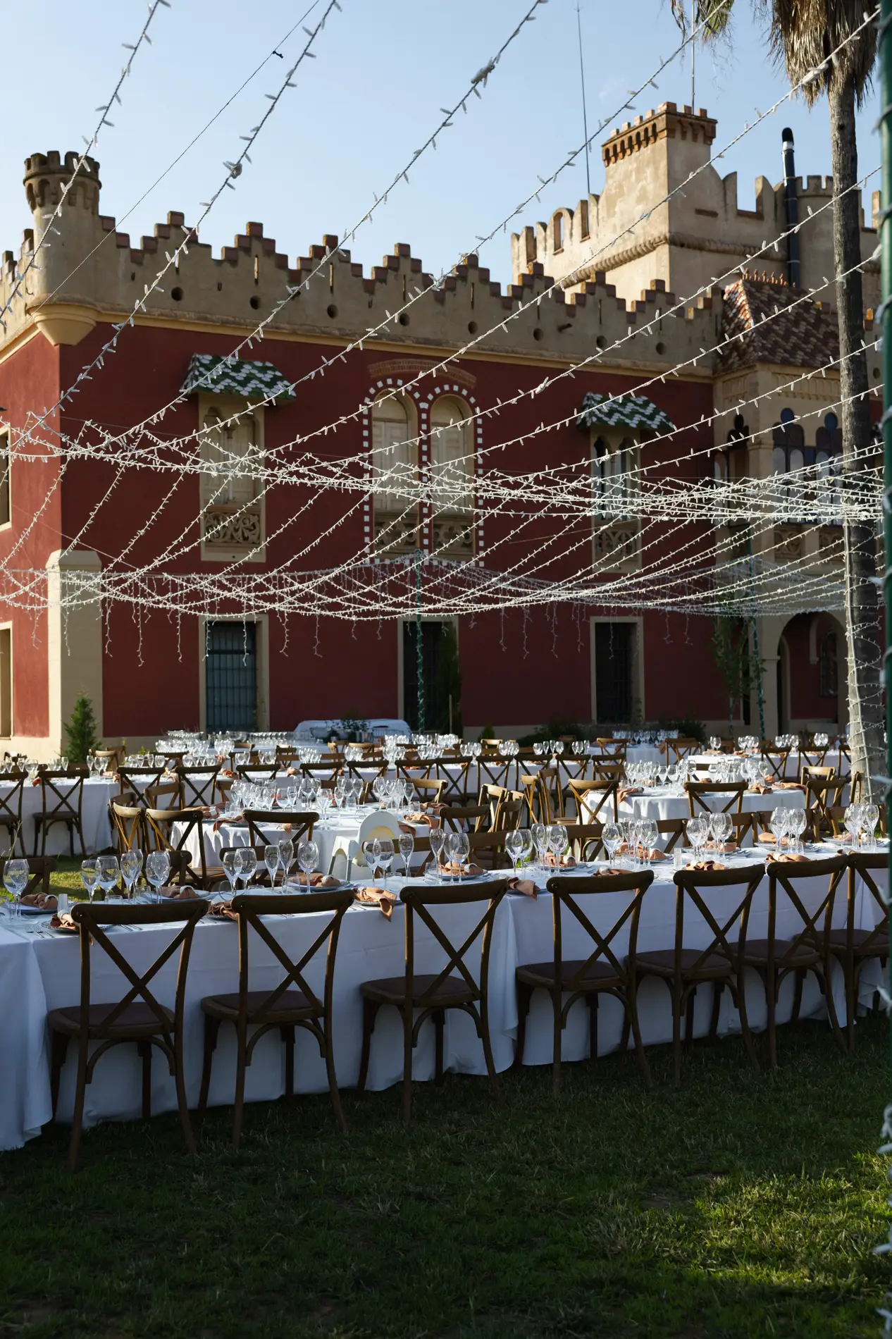 Mesas del banquete bajo guirnaldas de luces frente al palacete de Casa Colorada